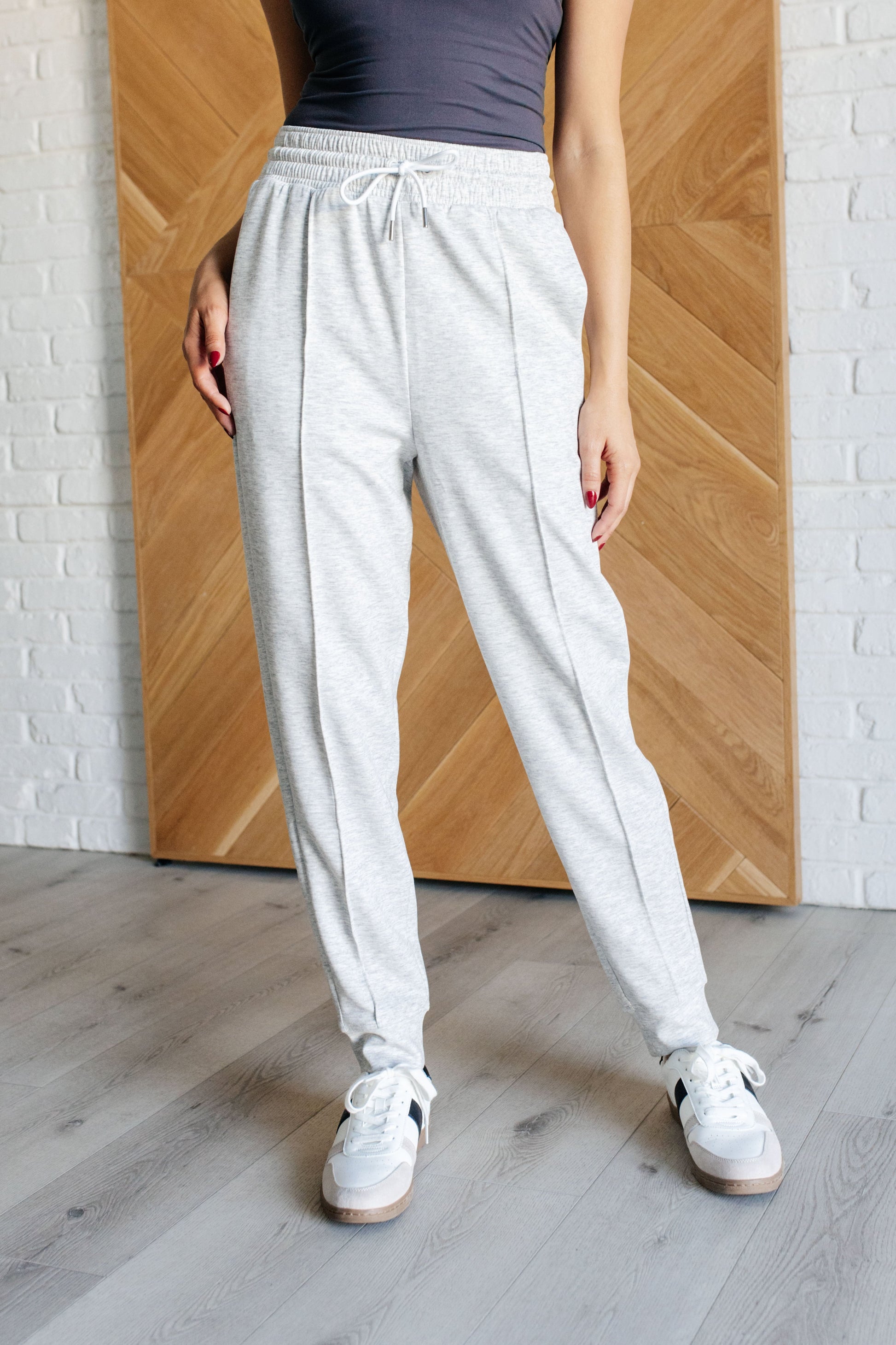 Center Seam Scuba Joggers in heather gray featuring a front seam, elastic waistline with functional drawstring, side pockets, and banded hem for a comfortable and stylish fit.