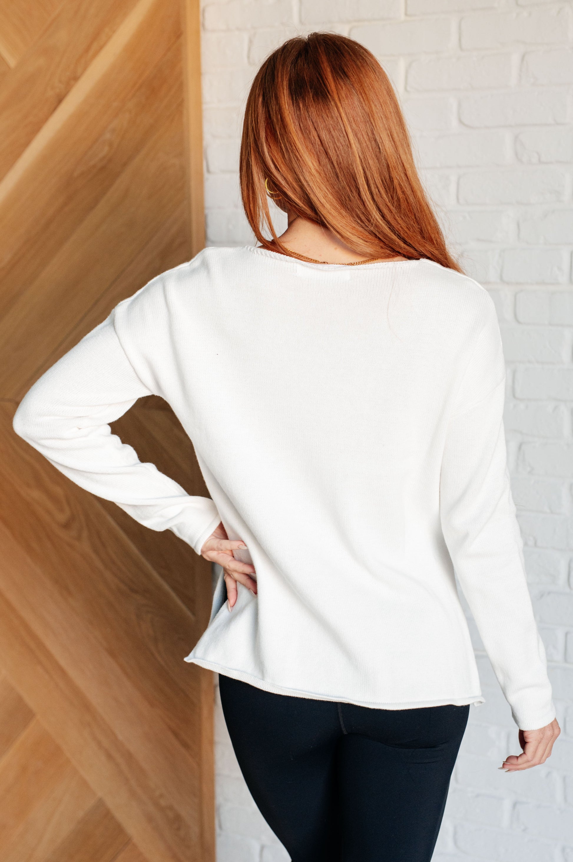 Women's white lightweight sweater with the text "Champagne Please" on the front, featuring a boat neck, long drop-shoulder sleeves, and a side slit.