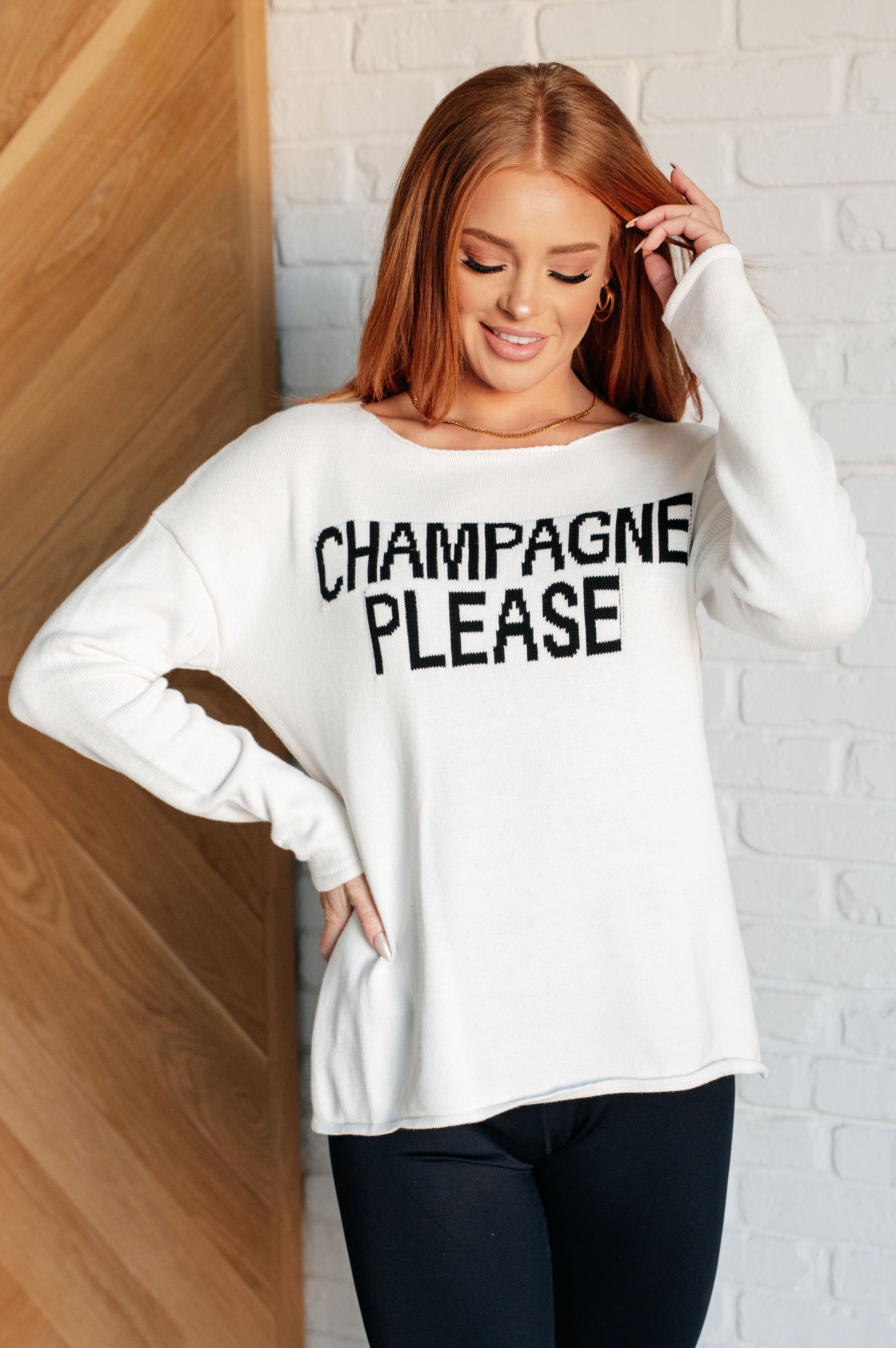 Women's white lightweight sweater with the text "Champagne Please" on the front, featuring a boat neck, long drop-shoulder sleeves, and a side slit.