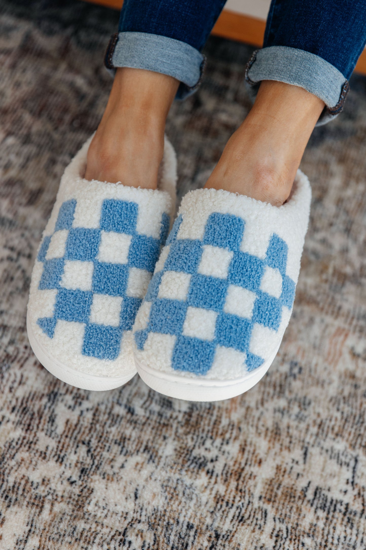 Blue and white checkered print slippers with a plush French terry upper, cushioned insole, and rubber sole.