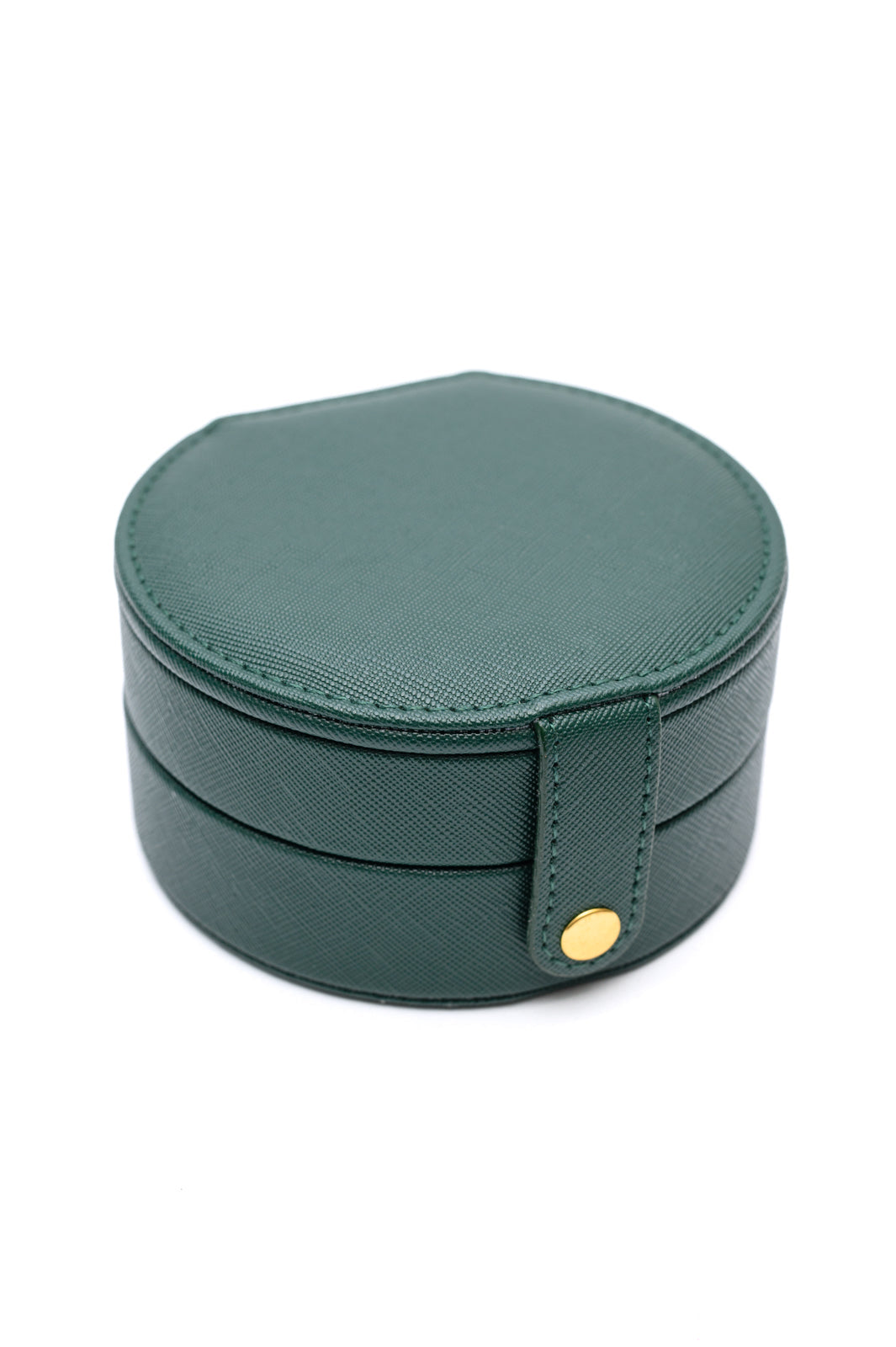 Circular Travel Jewelry Case in Green, with secure snap closure, small mirror, six ring slots, four perforated sections for earrings, six compartments for jewelry, and three necklace hooks.