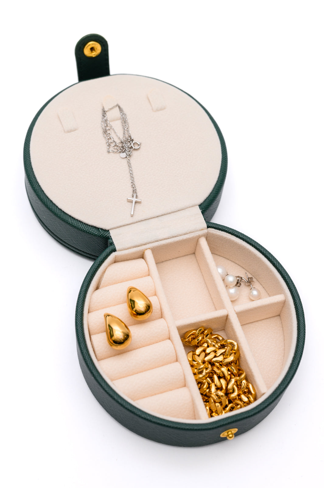 Circular Travel Jewelry Case in Green, with secure snap closure, small mirror, six ring slots, four perforated sections for earrings, six compartments for jewelry, and three necklace hooks.