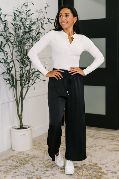 Model styling Cita Wide Leg Bottoms with long sleeve top for relaxed weekend look.