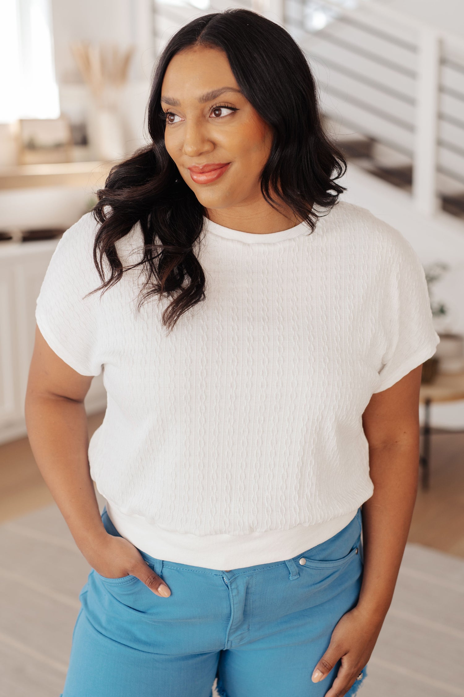 Plus size model front view of Claudine cable knit short sleeve top with ribbed neckline and cropped fit.