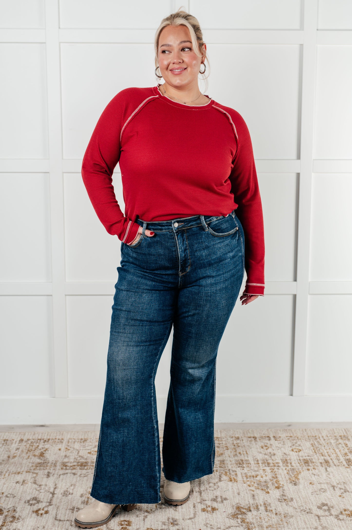 Red waffle knit top with raglan sleeves, exposed seams, and contrast stitching for a stylish and comfortable look. Features raw edges and light stretch.