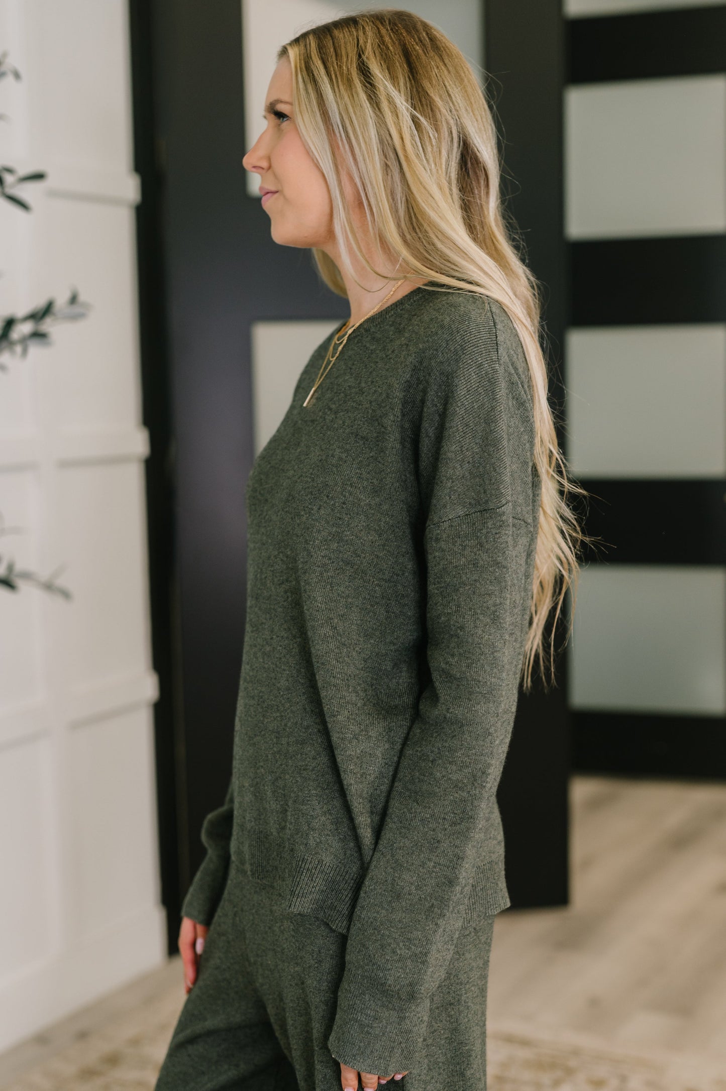 Back view of Clove Sweater in Moss showing drop shoulder and banded hem