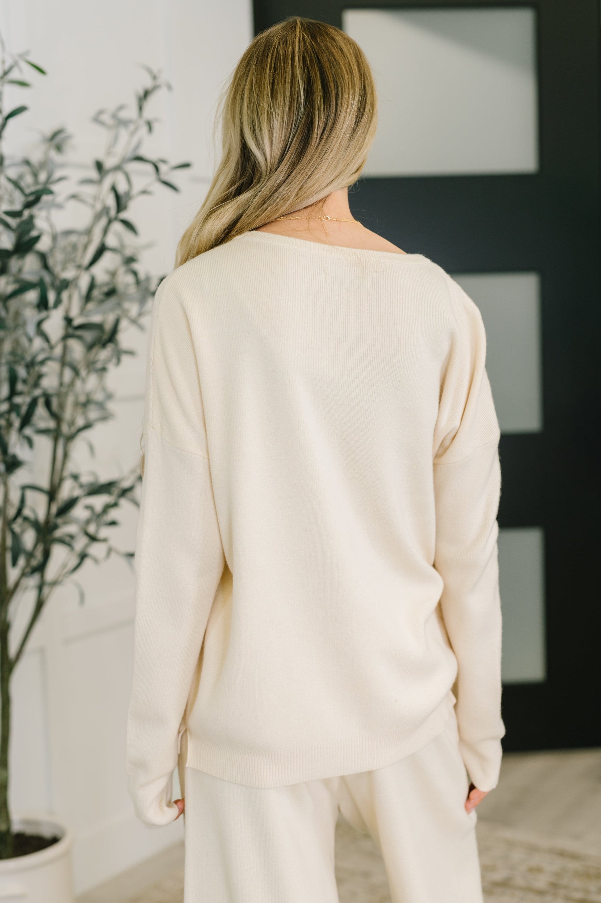 Back view of Clove Sweater in Oat with ribbed knit and banded hemline
