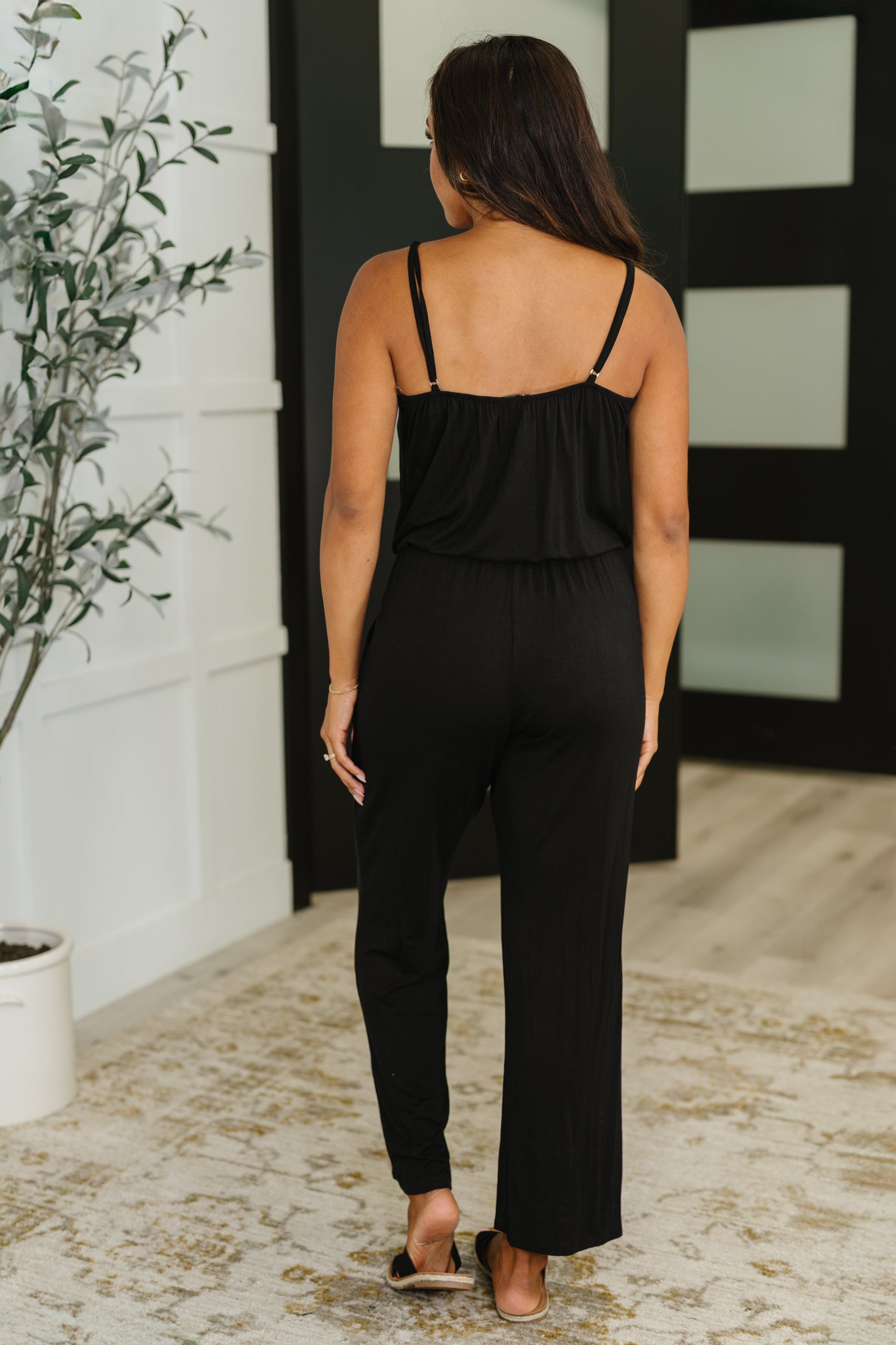 Back view of Viola Jumpsuit in Black with surplice straps and elastic waist