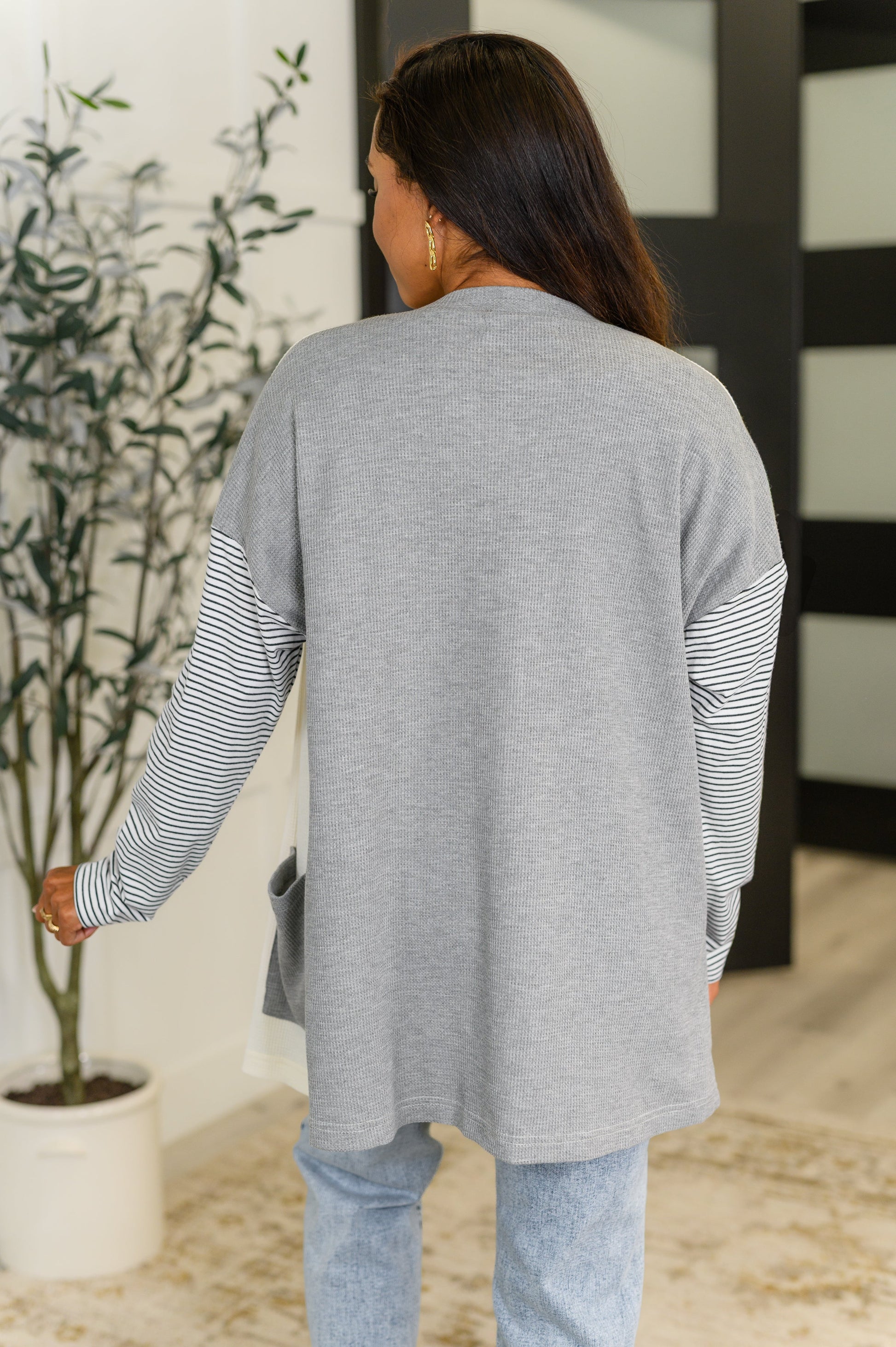 Back view of Evie color block cardigan with gray body, cream contrast, and relaxed fit.