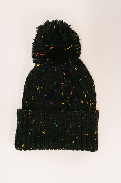 Flat lay of Cover Your Ears Pom Pom Beanie in black with cable knit and pom pom.