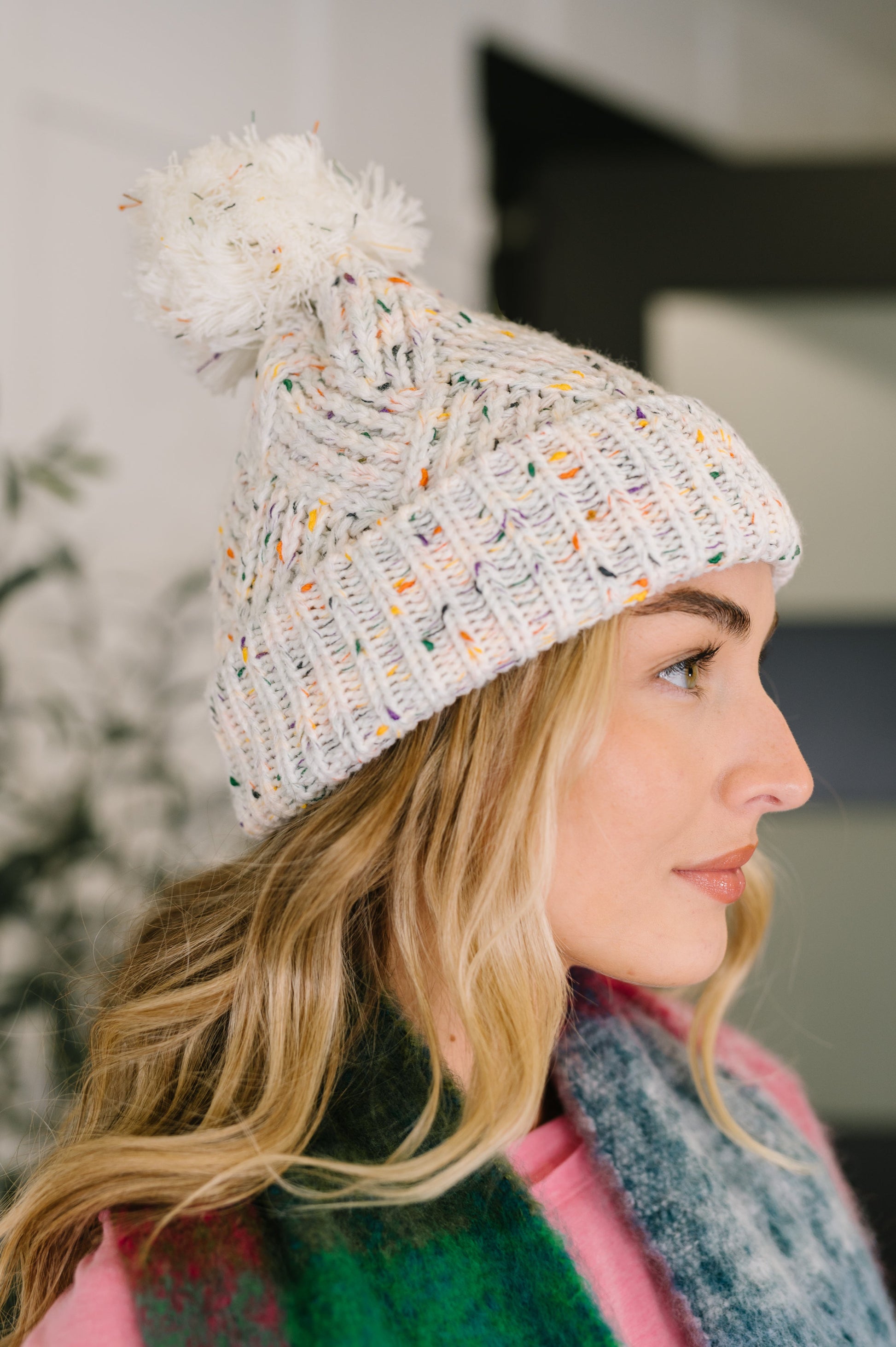 Side angle of Cover Your Ears Pom Pom Beanie highlighting soft cable texture.