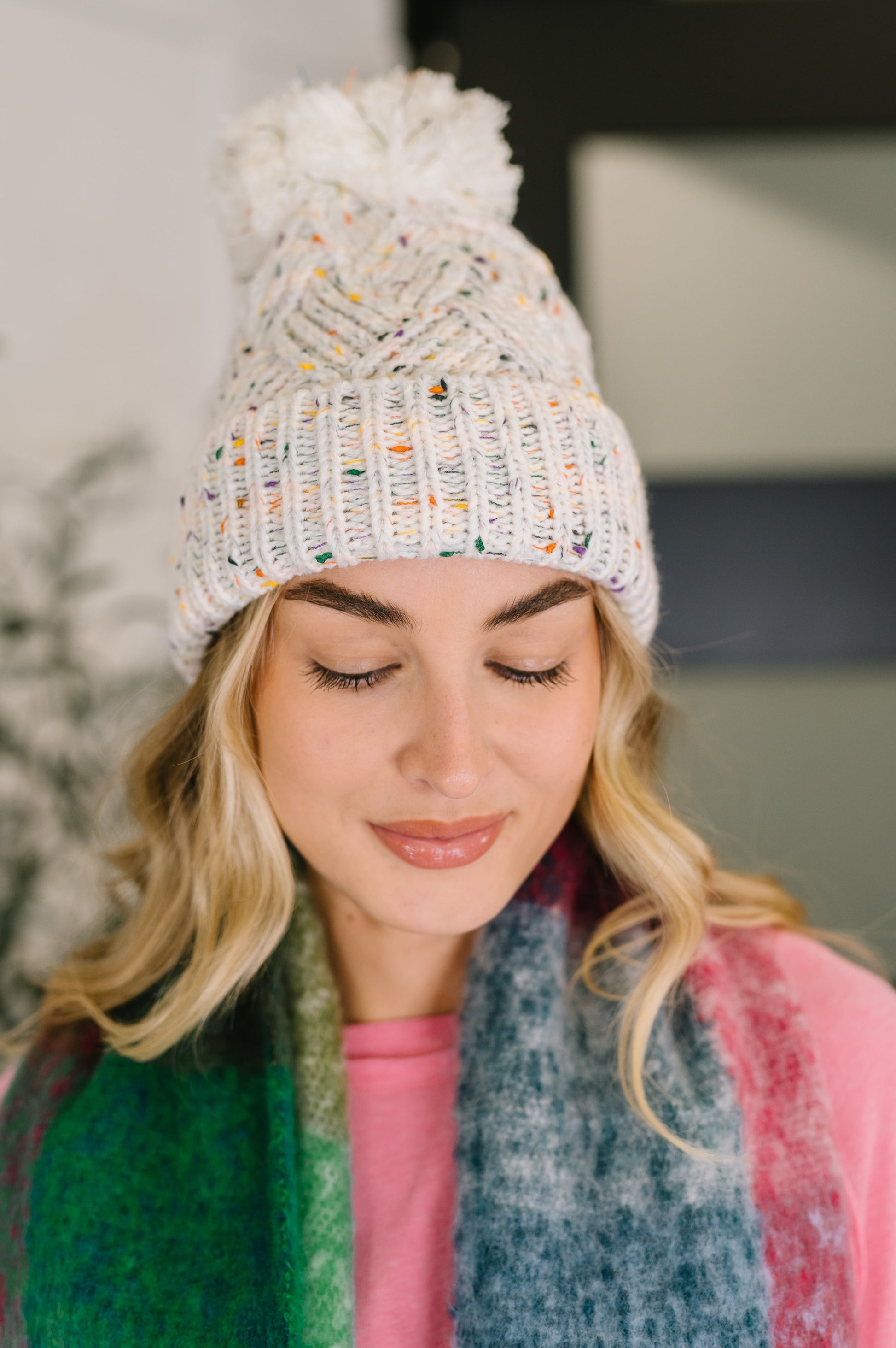 Cover Your Ears Pom Pom Beanie in ivory speckled cable knit with fluffy pom.