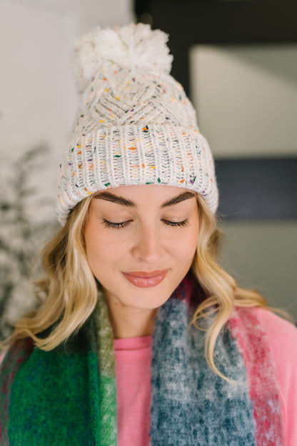 Cover Your Ears Pom Pom Beanie in ivory speckled cable knit with fluffy pom.