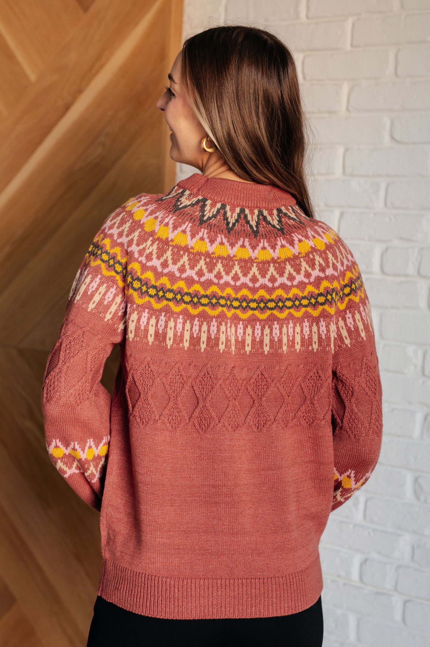  A mid-weight sweater knit featuring a Fair Isle pattern in red, yellow, pink, white, and black. The sweater has a ribbed crew neckline, long balloon sleeves, and a comfort-fit silhouette.