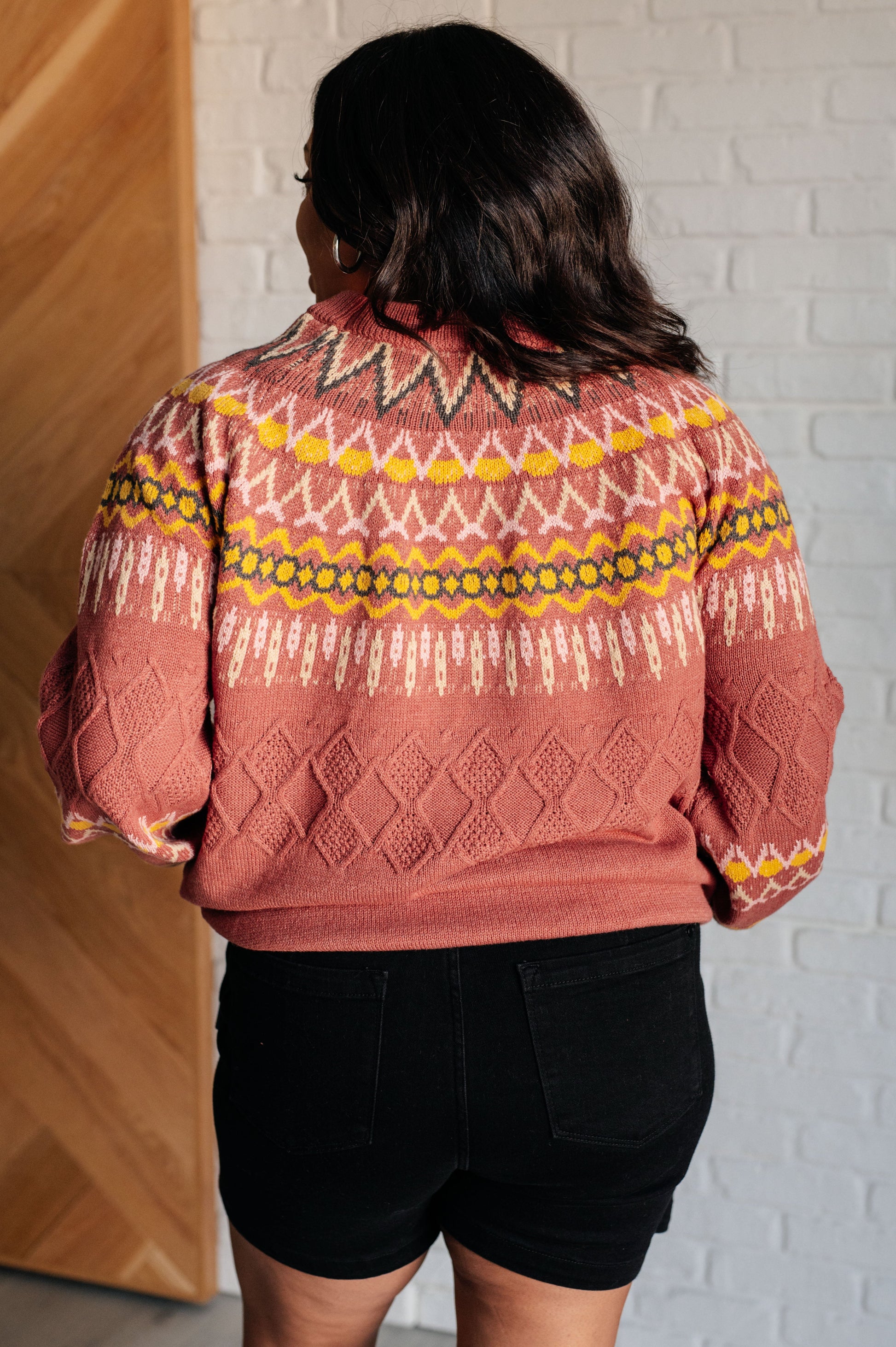  A mid-weight sweater knit featuring a Fair Isle pattern in red, yellow, pink, white, and black. The sweater has a ribbed crew neckline, long balloon sleeves, and a comfort-fit silhouette.