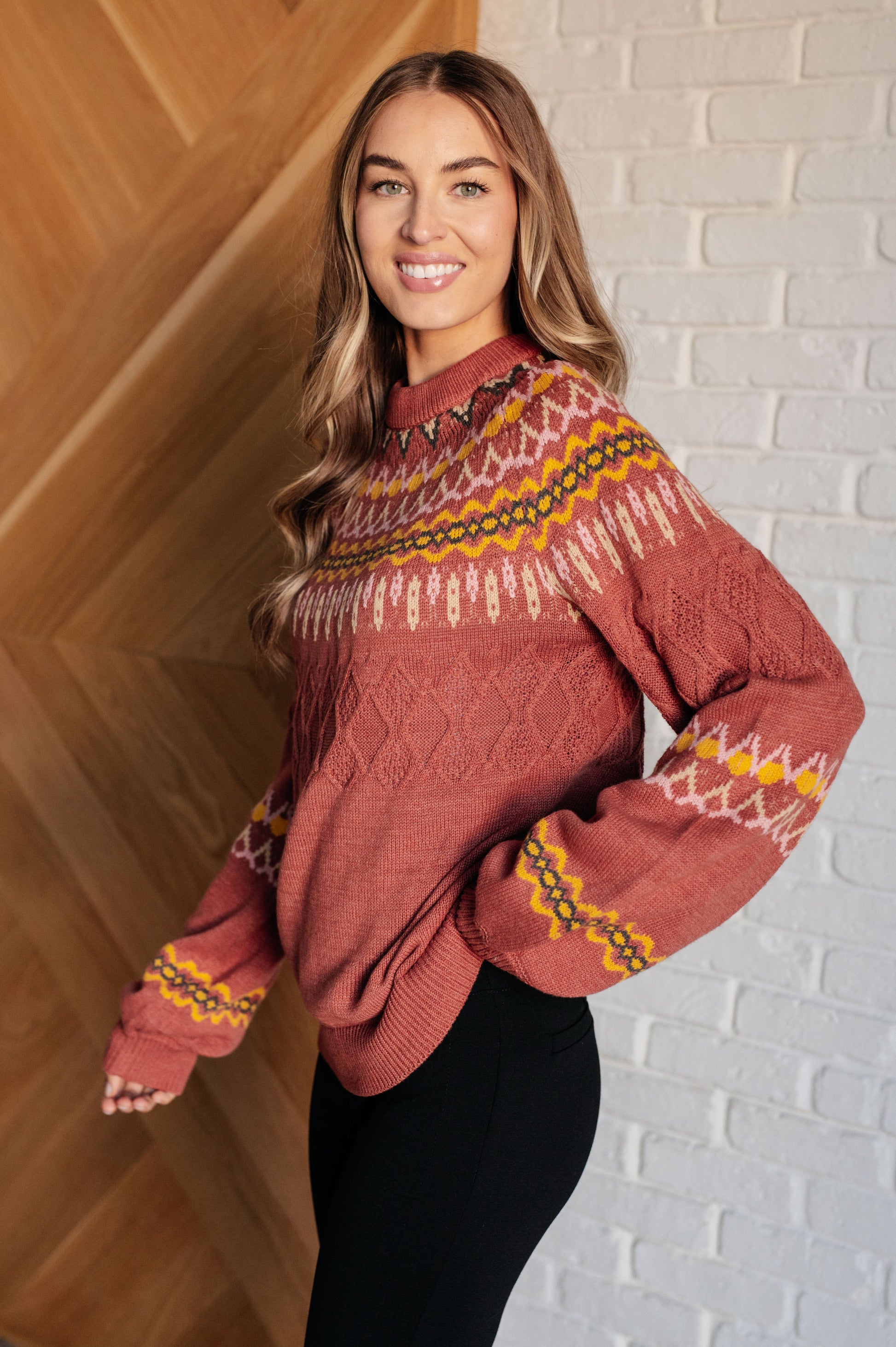  A mid-weight sweater knit featuring a Fair Isle pattern in red, yellow, pink, white, and black. The sweater has a ribbed crew neckline, long balloon sleeves, and a comfort-fit silhouette.