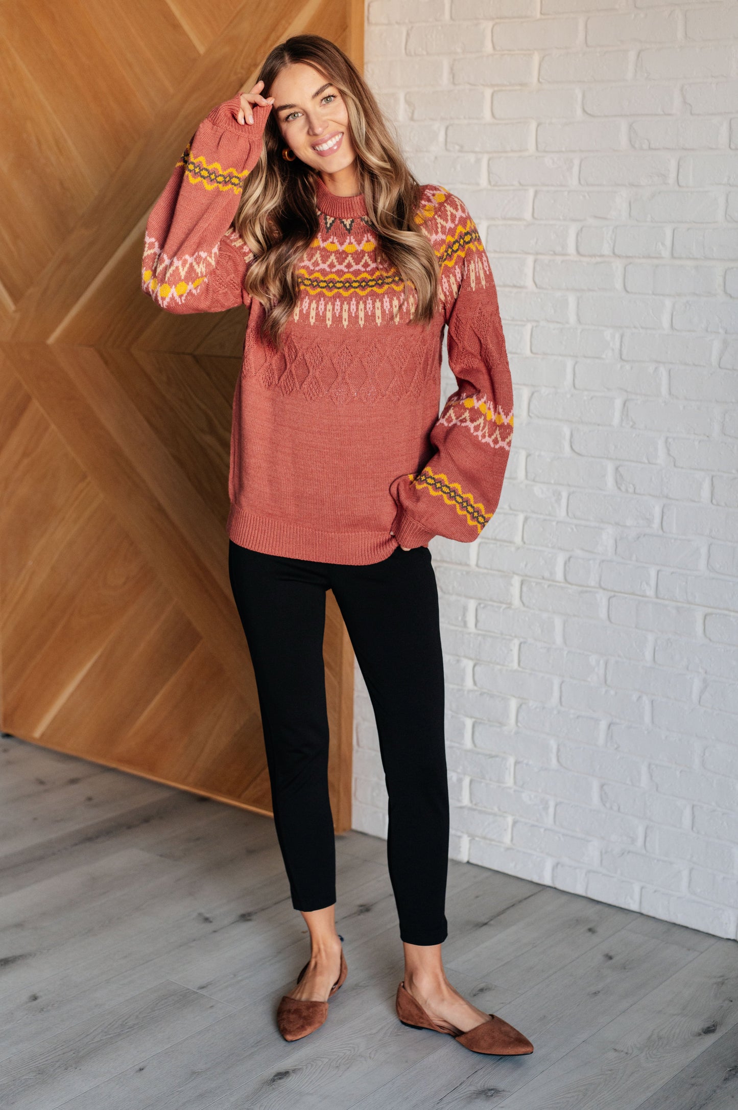  A mid-weight sweater knit featuring a Fair Isle pattern in red, yellow, pink, white, and black. The sweater has a ribbed crew neckline, long balloon sleeves, and a comfort-fit silhouette.