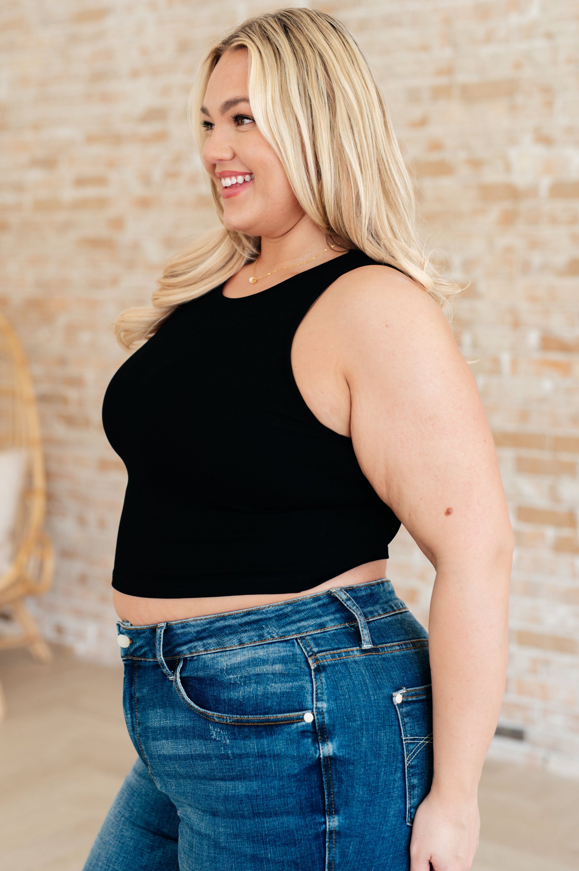 Side view plus size black rib knit cropped tank top with round neckline, sleeveless layering essential.