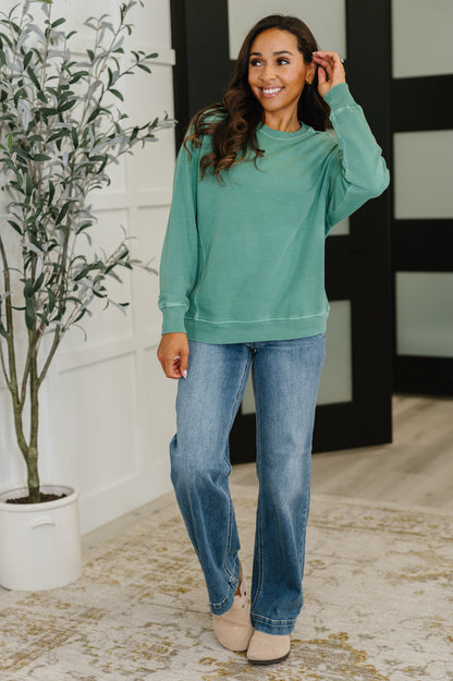 Full body view of Nicia Dark Green Mineral Wash Pullover styled with jeans