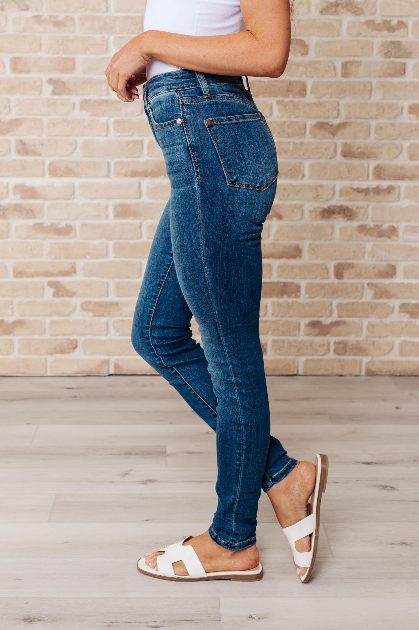 Dark wash high-rise skinny jeans with 4-way stretch for a comfortable fit, featuring a zip fly closure and undistressed design.