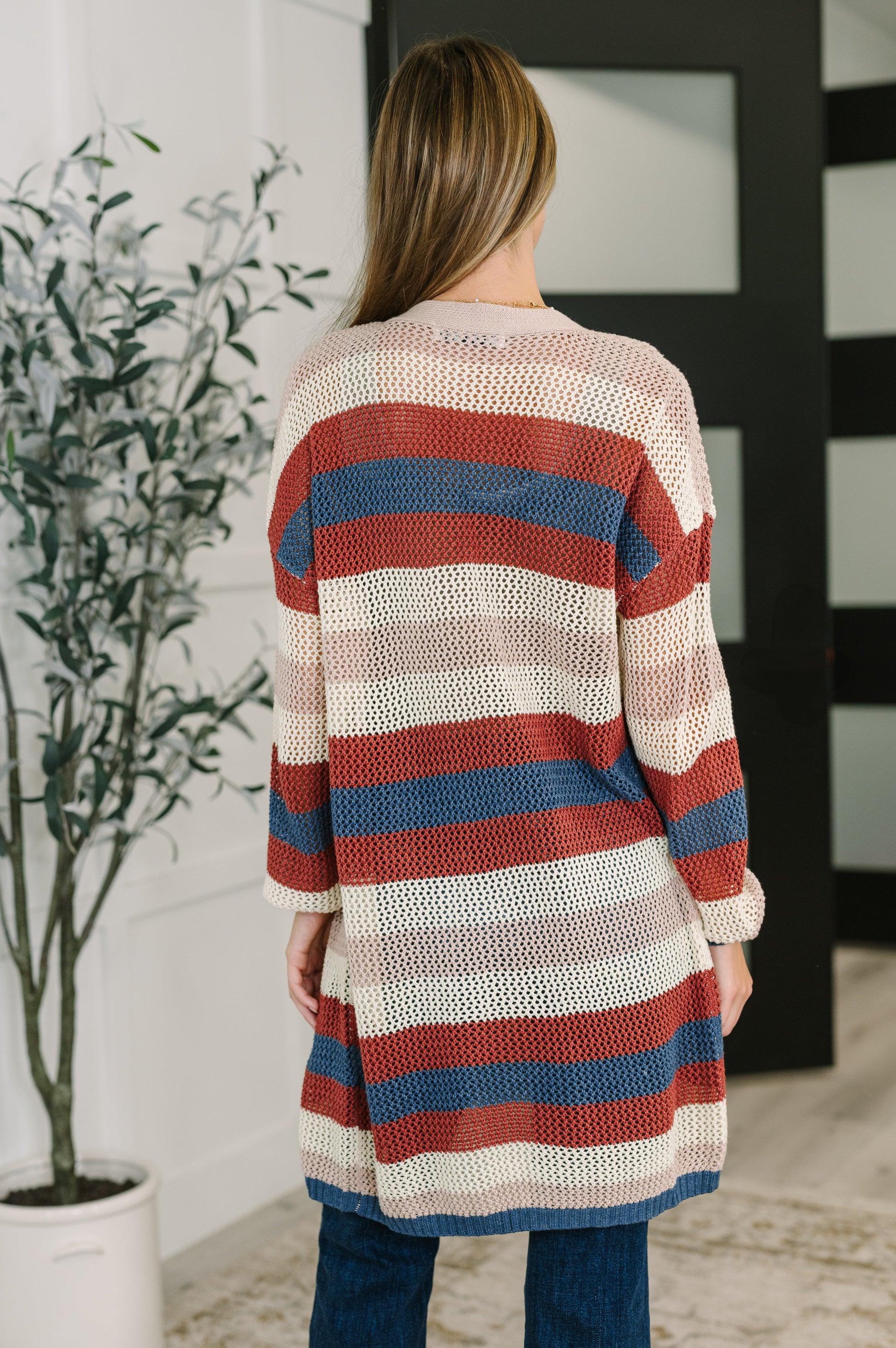 Back view of Carly Striped Knit Cardigan featuring rust base with bold stripe pattern.