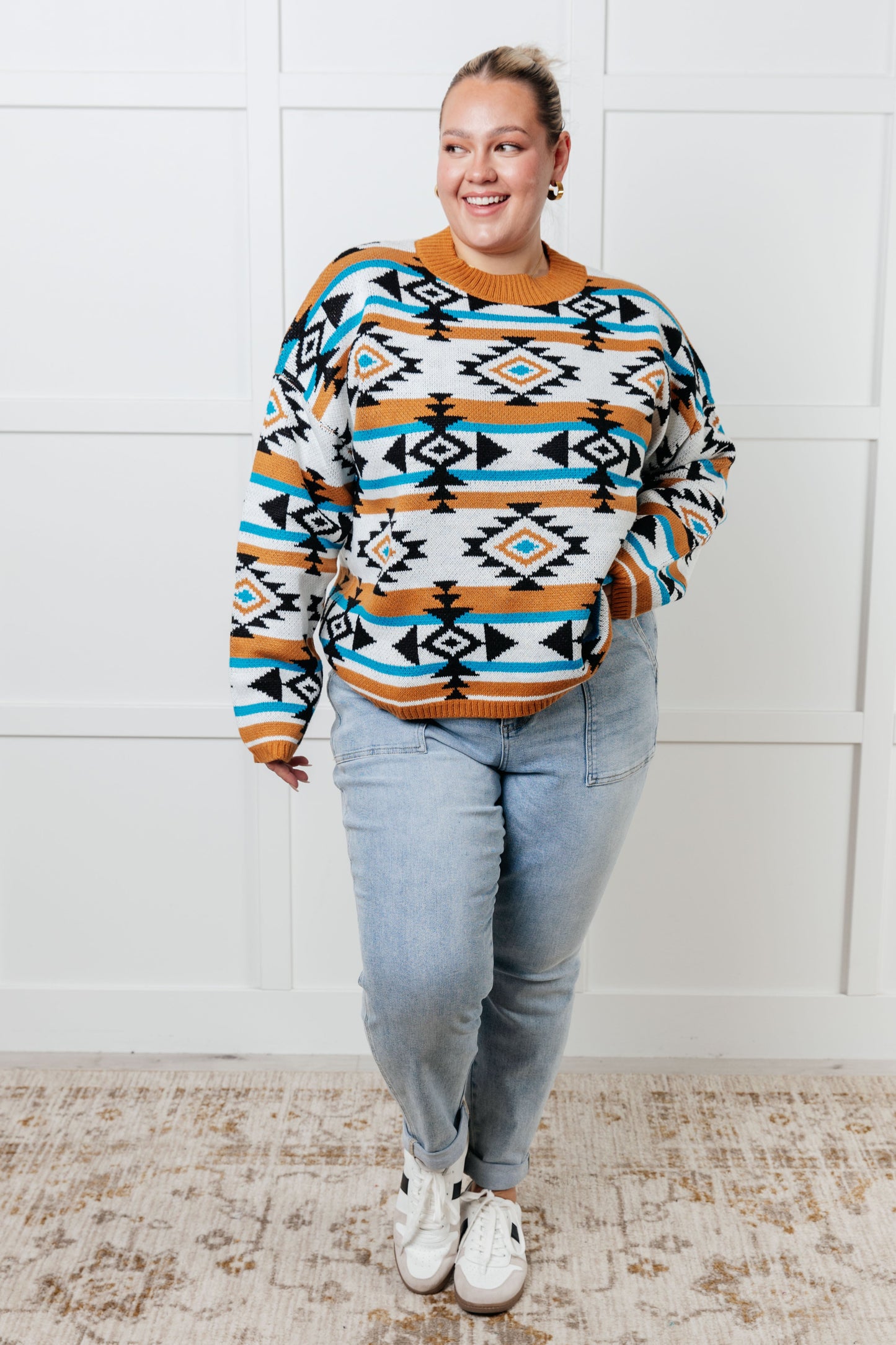 Soft midweight sweater with geometric striped pattern in earthy tones. Features a banded ribbed round neckline, long sleeves with drop shoulders, and ribbed cuffs and hem for a snug fit.