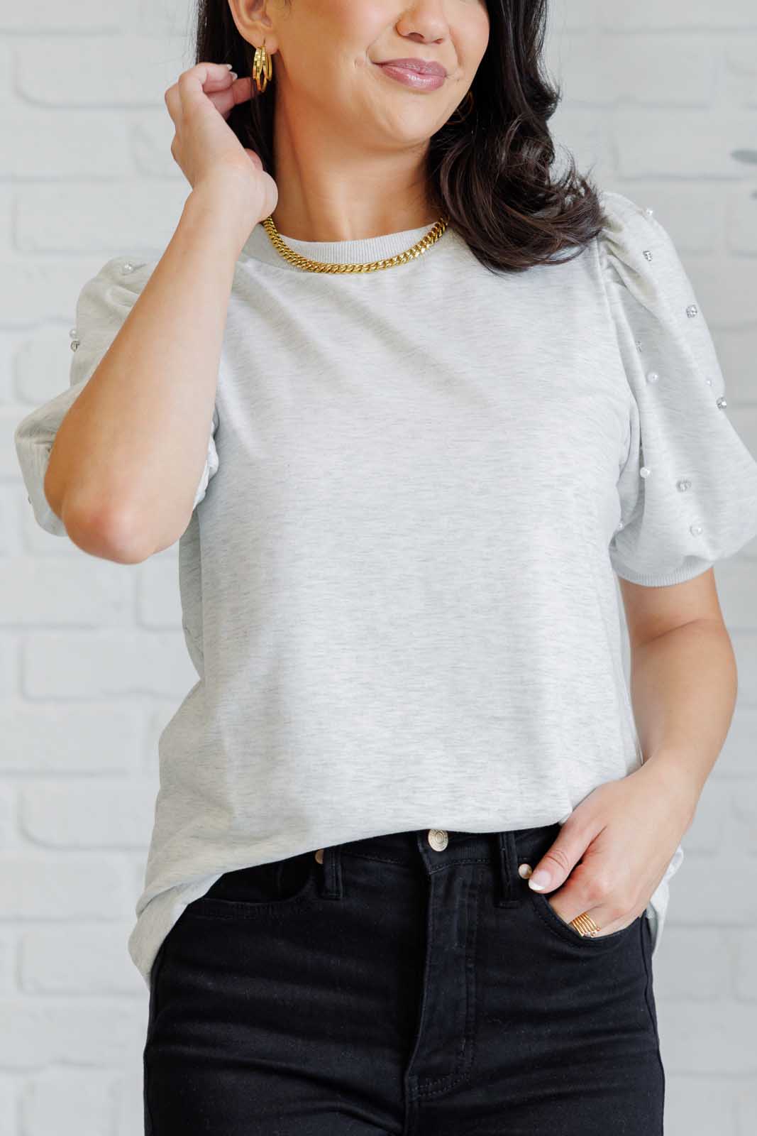 Light gray French terry top with a ribbed neckline, short balloon sleeves embellished with pearl and faux diamond accents, and ribbed sleeve cuffs.