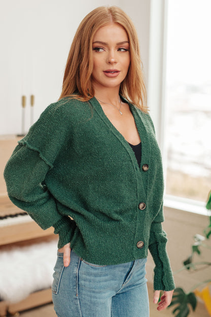 Side angle of the Dido Cardigan in Green highlighting ribbed cuffs and relaxed fit.