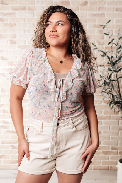 Plus size floral mesh bodysuit with fluttery ruffle details and square v-neckline.