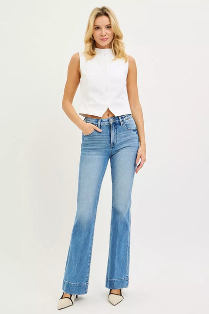 Model adjusting Diya Mid-Rise Flare Jeans to show 4-way stretch comfort.