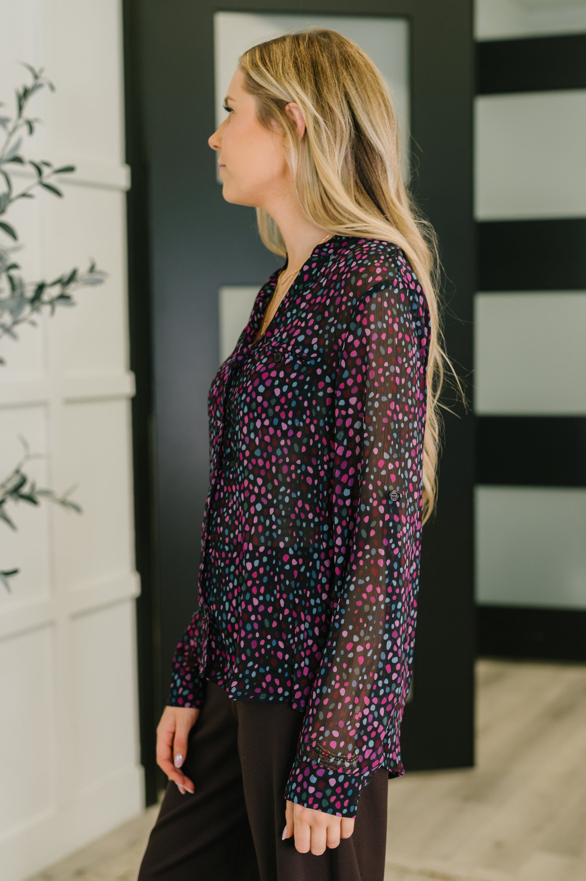 Side view of Miranda Polka Dot Blouse with long sleeves and flowy hemline.