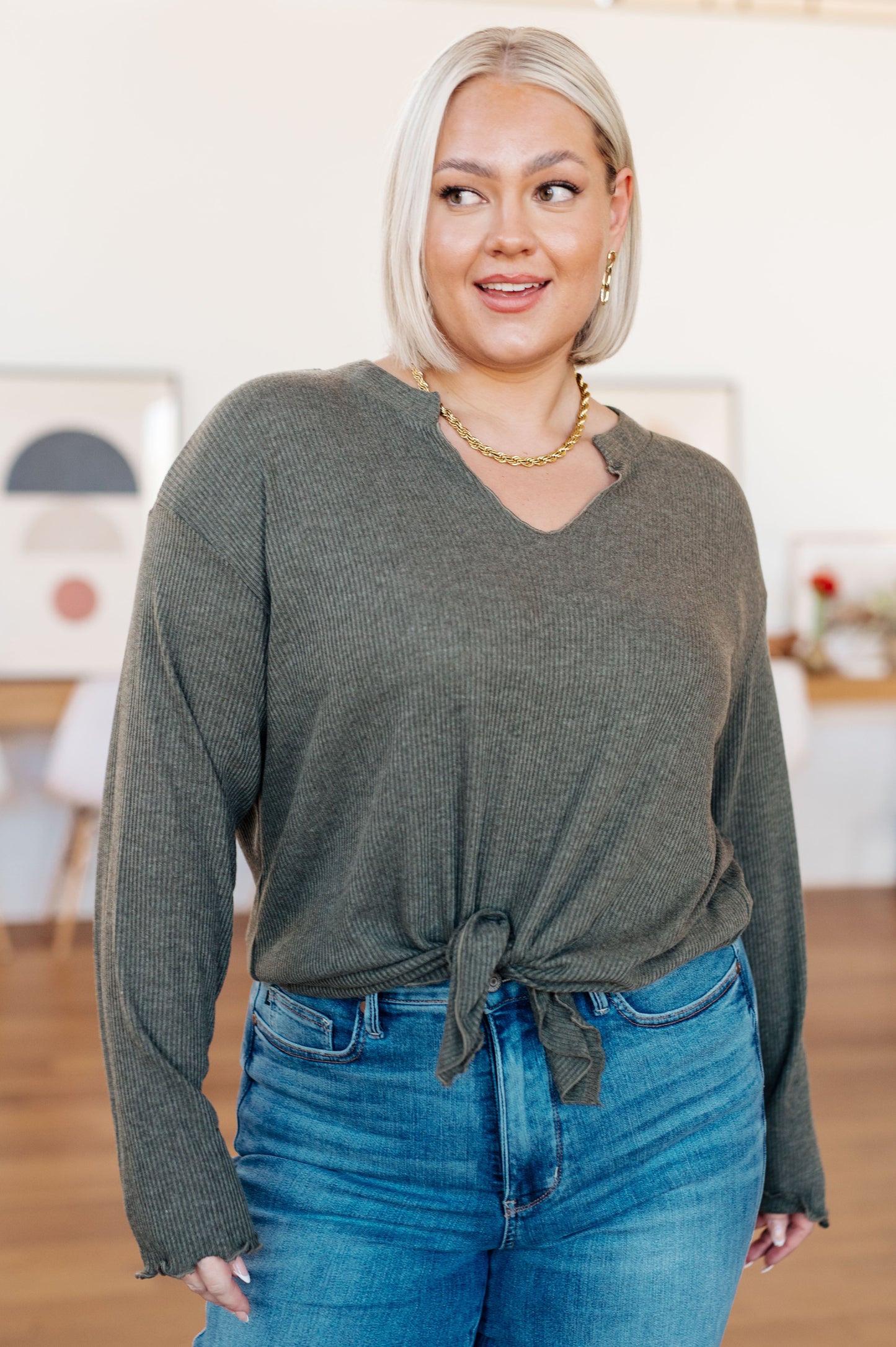 Sage gray ribbed knit top featuring a flirty front slit with tie detail, playful lettuce hem, and a flattering "Gabby" V-neckline, perfect for casual or chic outfits.