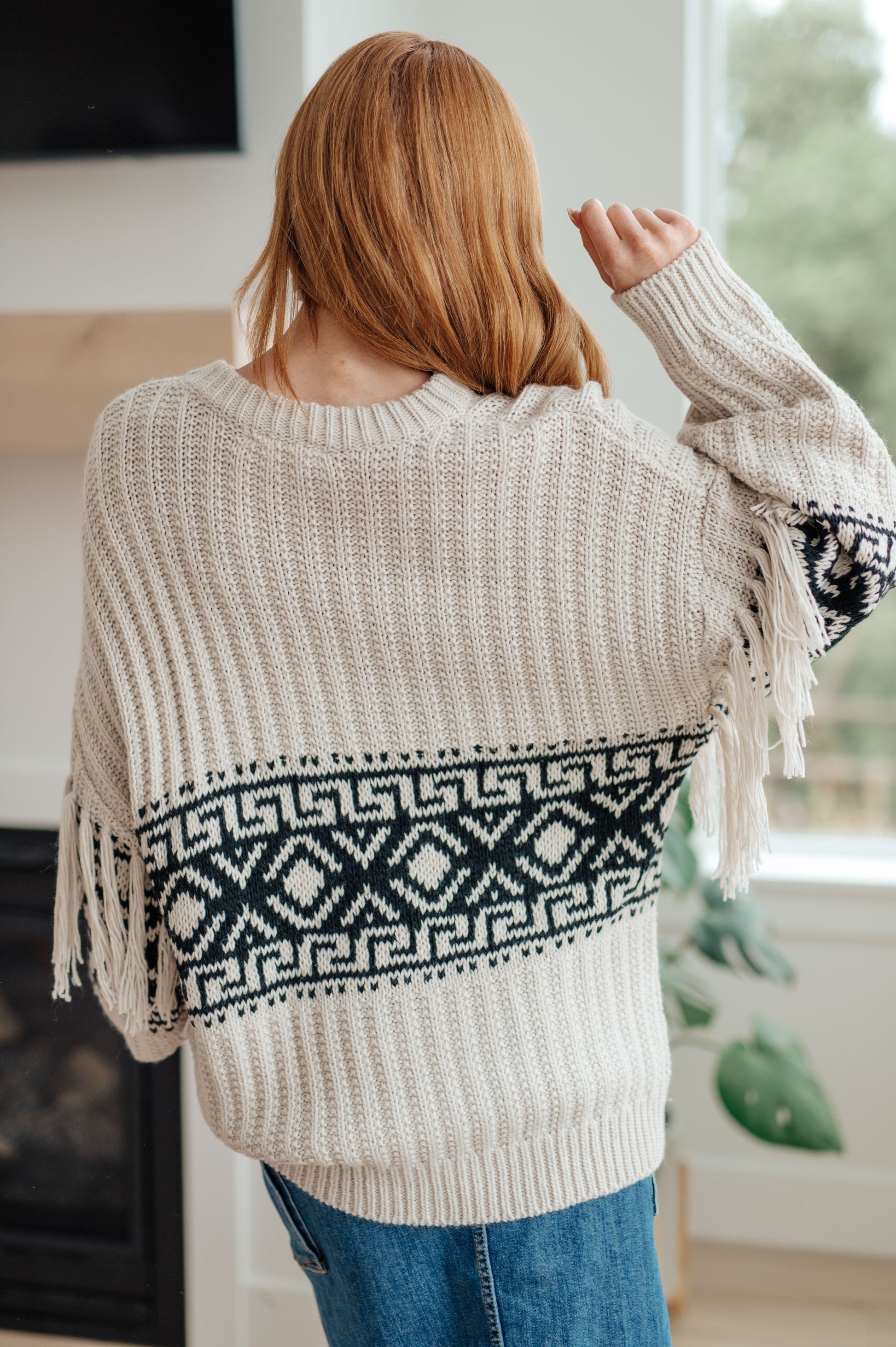 Woman's mid-weight sweater with a geometric print, featuring fringe trim, a ribbed crew neckline, long balloon sleeves with drop shoulders, and a comfort fit.