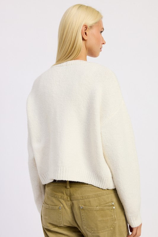 Back view of Donna Cropped Cardigan showing ivory knit and heart details.