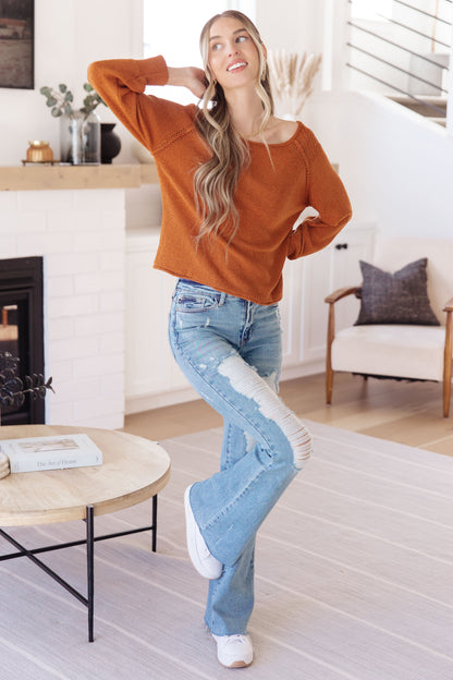 Angled front view of Dorothy Sweater in rust with round neckline and stylish exposed seams