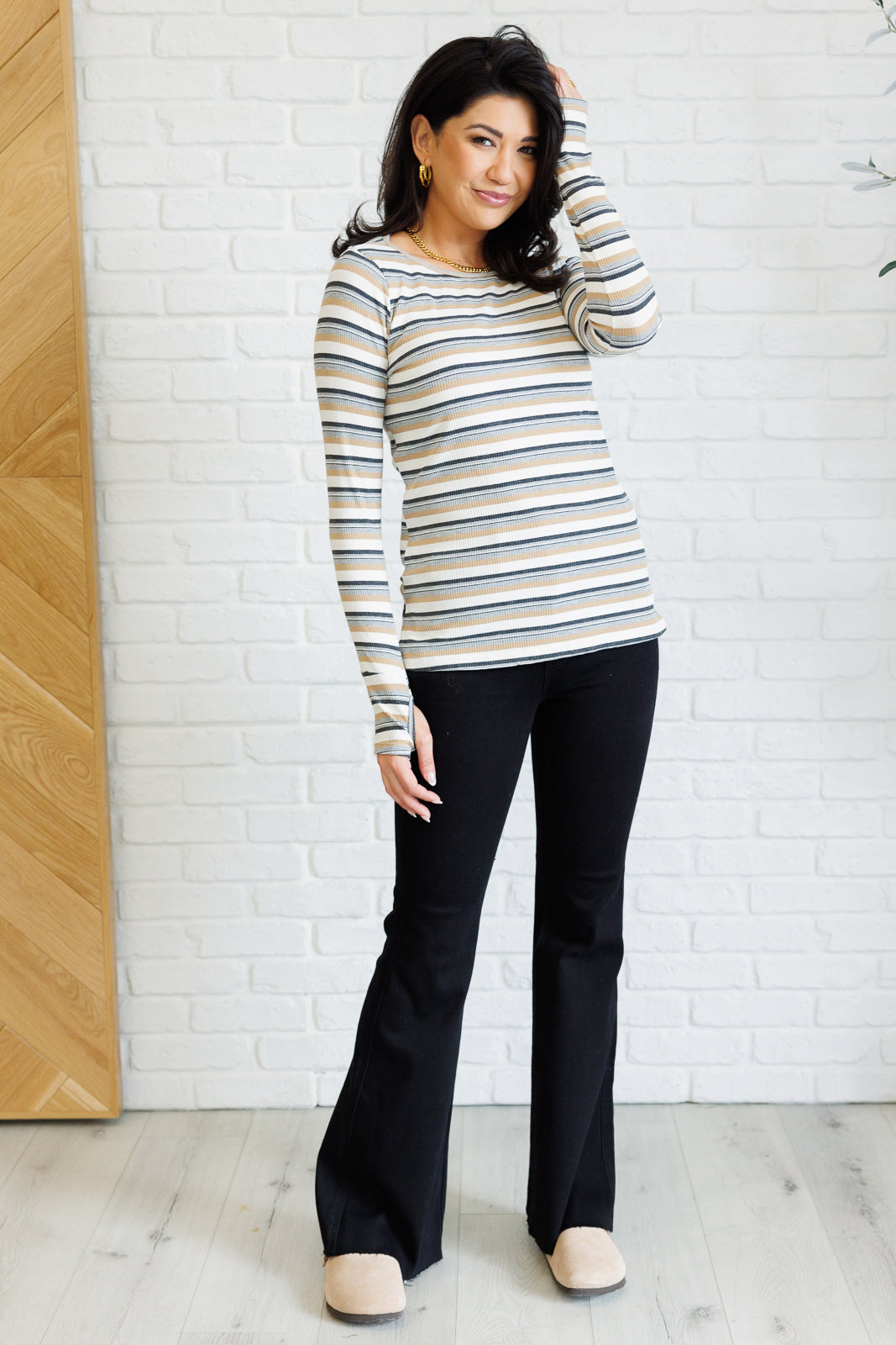 Women's ribbed knit striped top with a round neckline, long sleeves, thumbholes, and side slits.