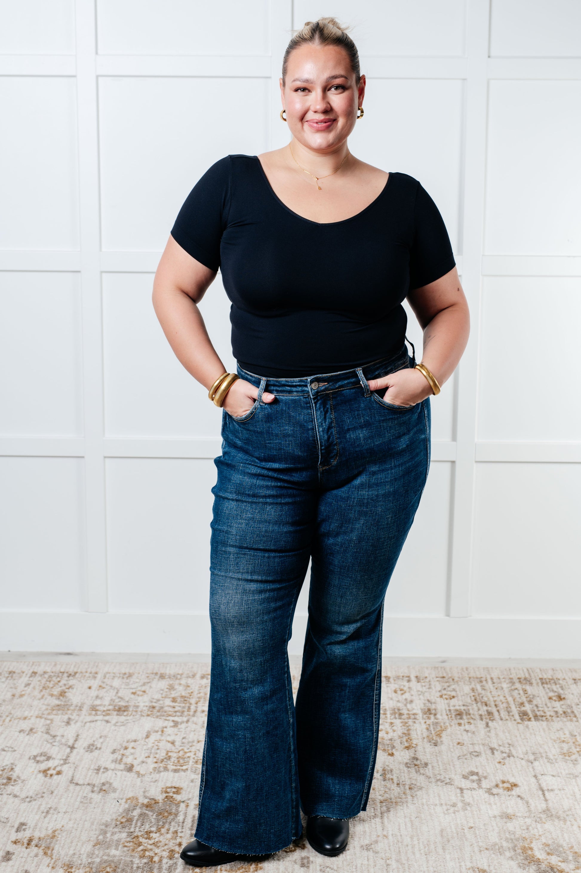 Judy Blue Edna High Rise Control Top Shield Pocket Flare Jeans in dark wash, featuring tummy control, raw hem, zip fly, and unique shield pockets.