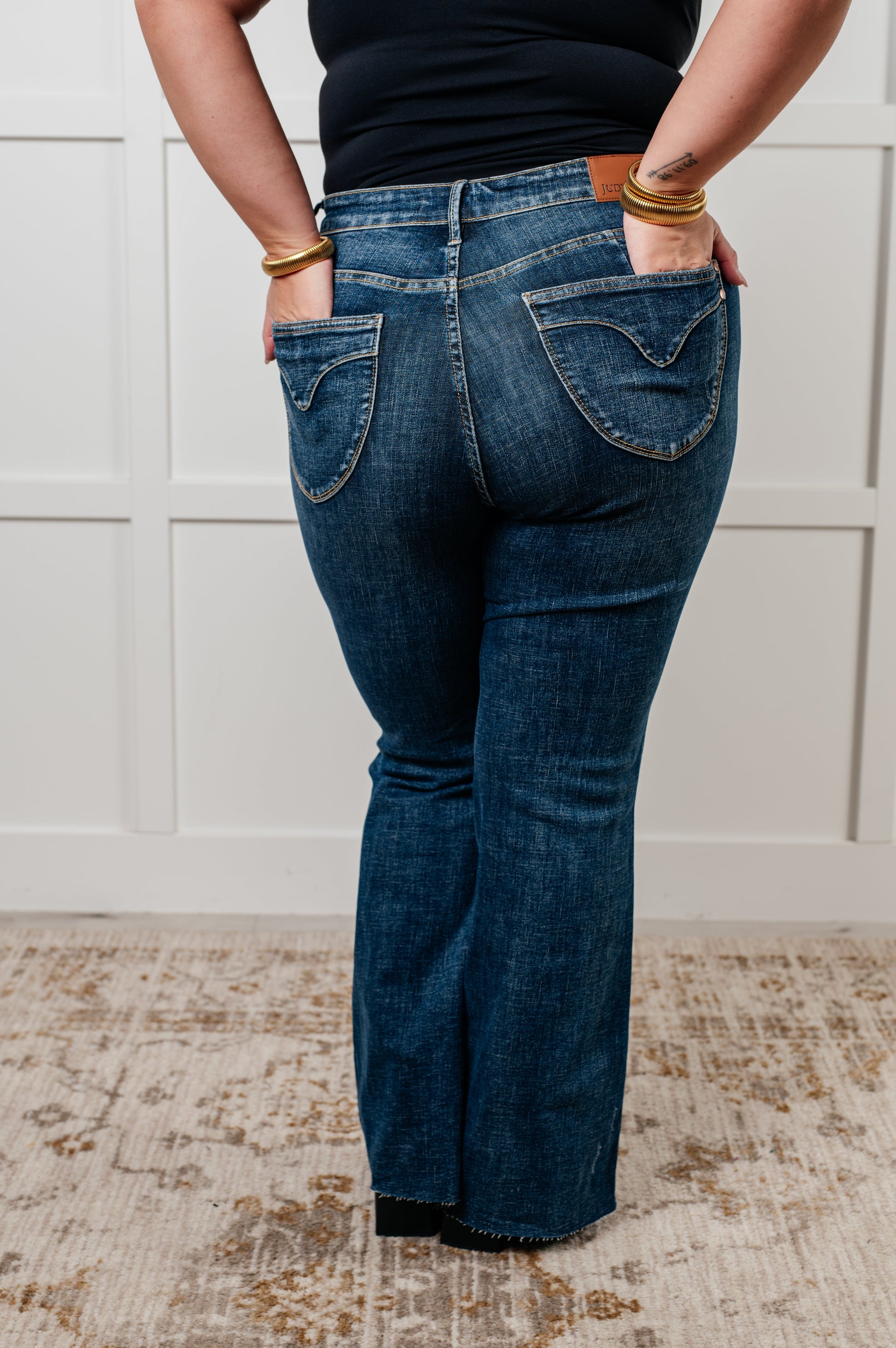 Judy Blue Edna High Rise Control Top Shield Pocket Flare Jeans in dark wash, featuring tummy control, raw hem, zip fly, and unique shield pockets.