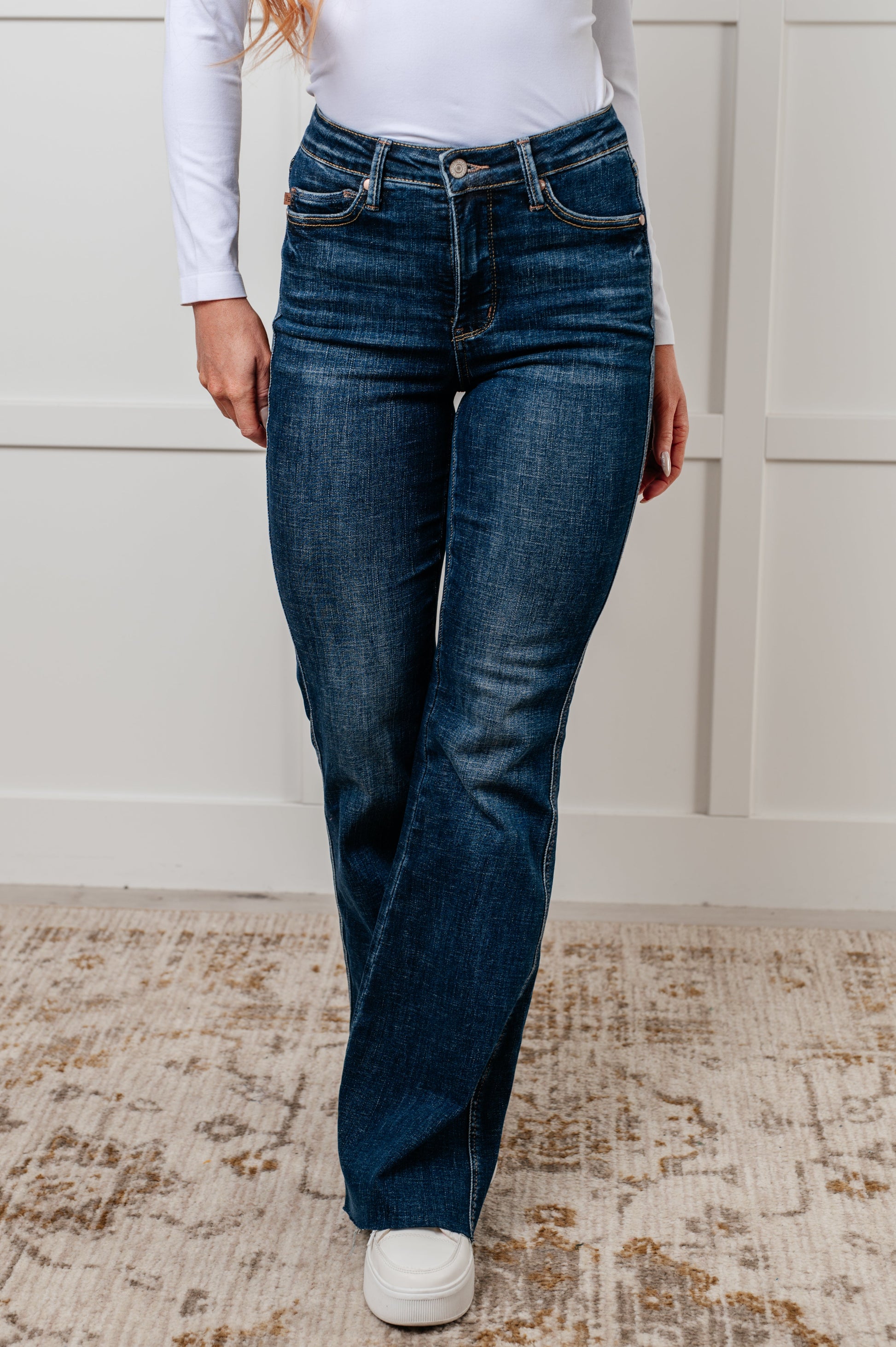 Judy Blue Edna High Rise Control Top Shield Pocket Flare Jeans in dark wash, featuring tummy control, raw hem, zip fly, and unique shield pockets.