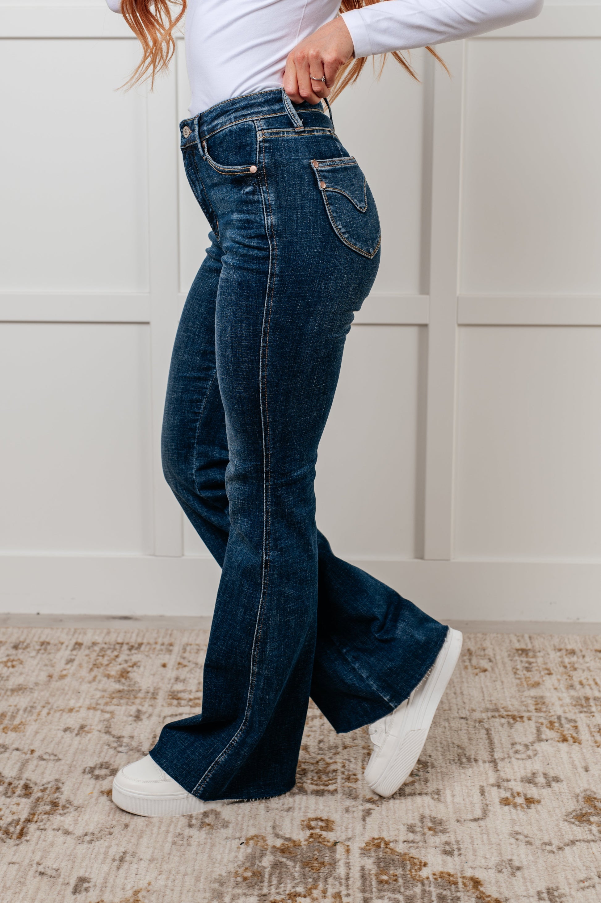 Judy Blue Edna High Rise Control Top Shield Pocket Flare Jeans in dark wash, featuring tummy control, raw hem, zip fly, and unique shield pockets.