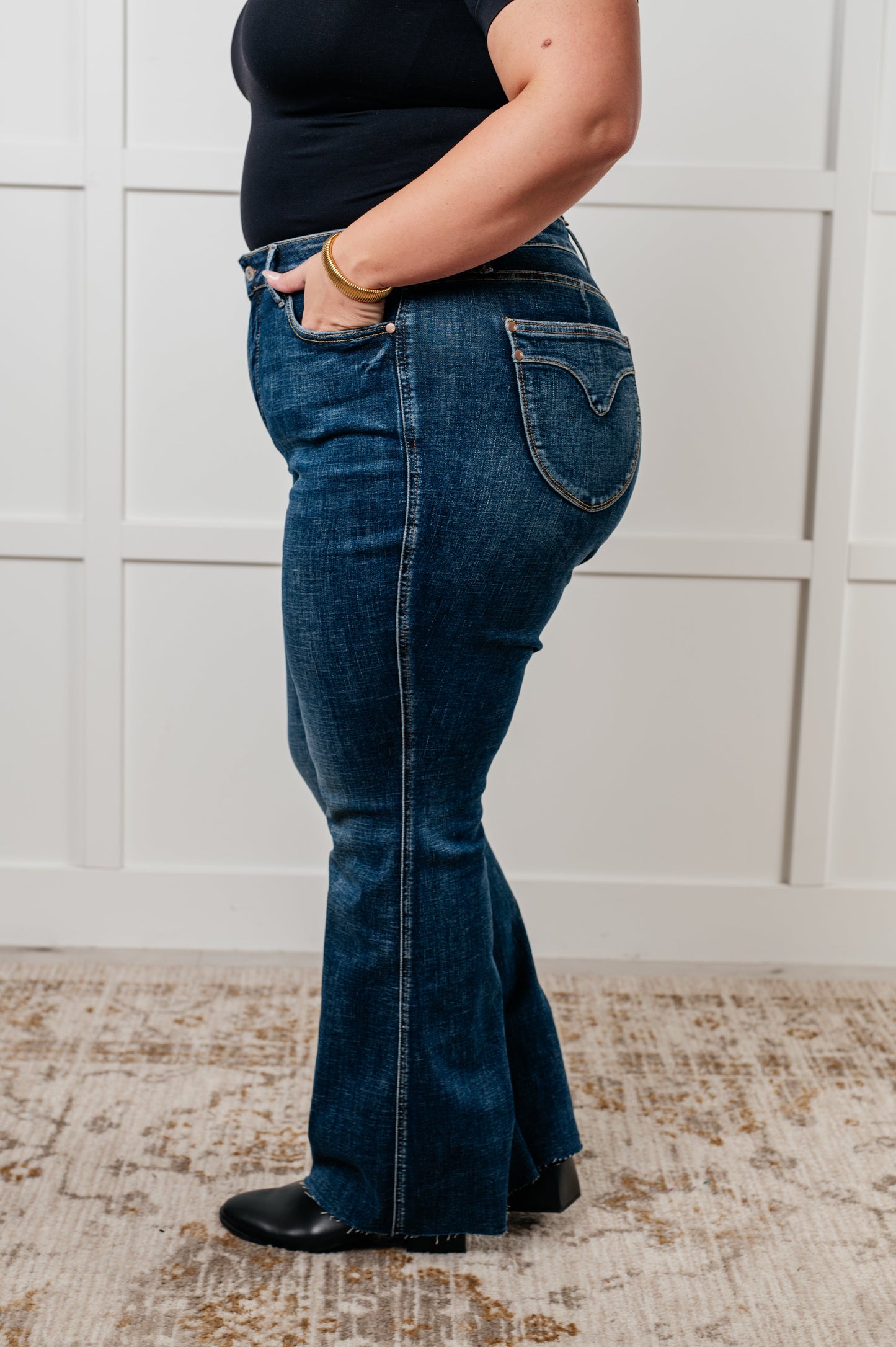 Judy Blue Edna High Rise Control Top Shield Pocket Flare Jeans in dark wash, featuring tummy control, raw hem, zip fly, and unique shield pockets.