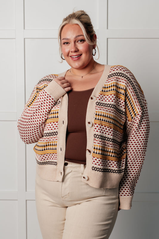 Beige cardigan with red and mustard yellow stripes, made of cozy sweater knit with V-neckline, full front button closures, drop shoulders, and ribbed cuffs and hemline.