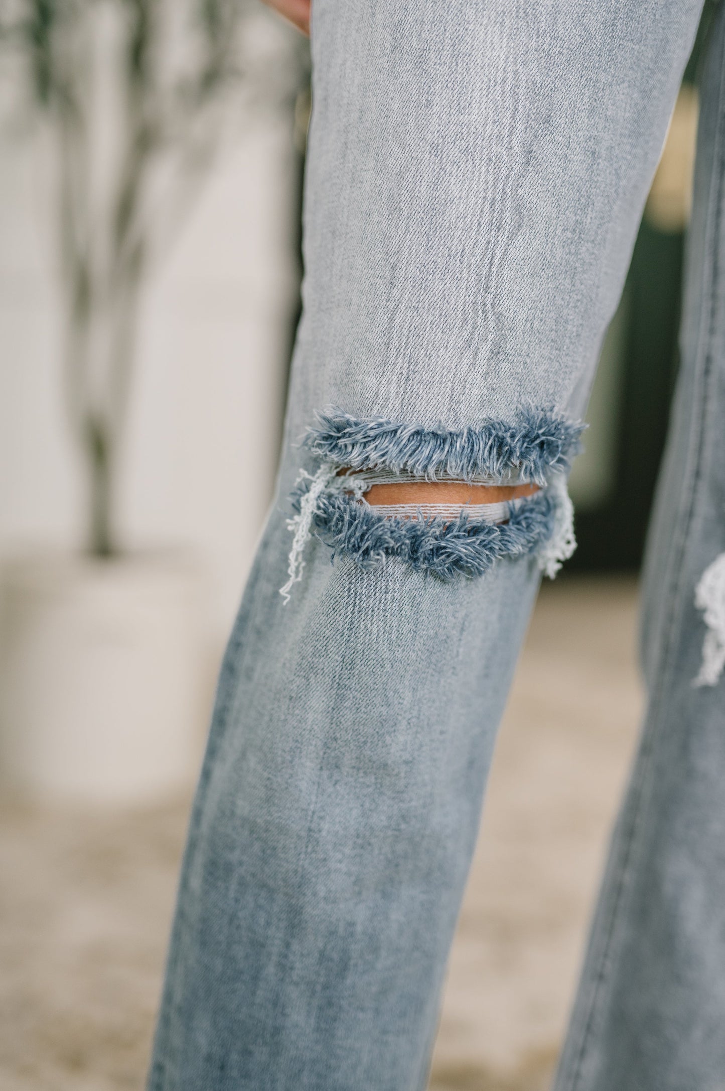 Close up of Elaine Mid Rise Boyfriend Jeans by Judy Blue distressed knee detail.