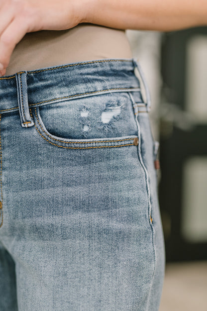 Close up of Elaine Mid Rise Boyfriend Jeans by Judy Blue distressed denim detail.