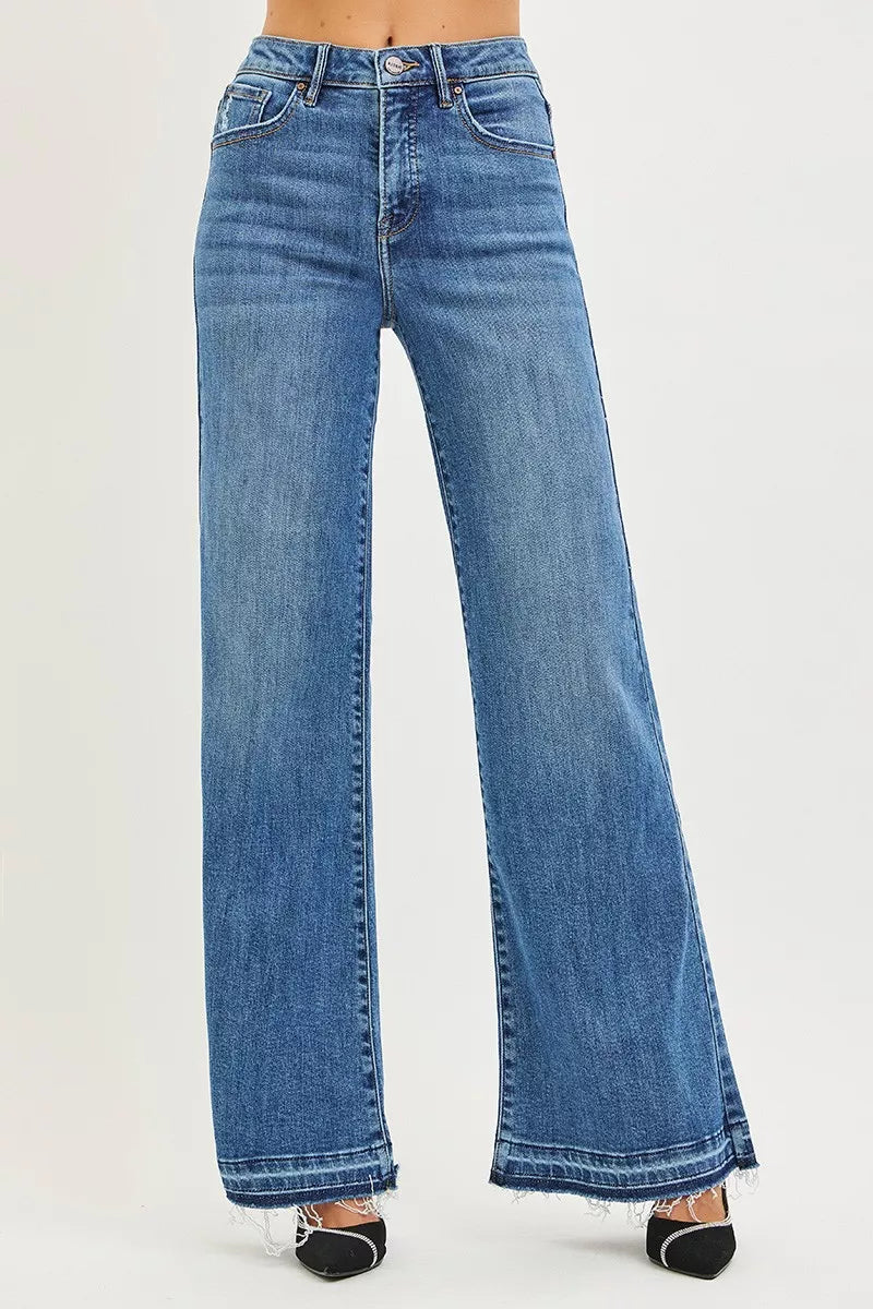 Model wearing Elizabeth High Rise Wide Leg Jeans in medium wash with raw hem.