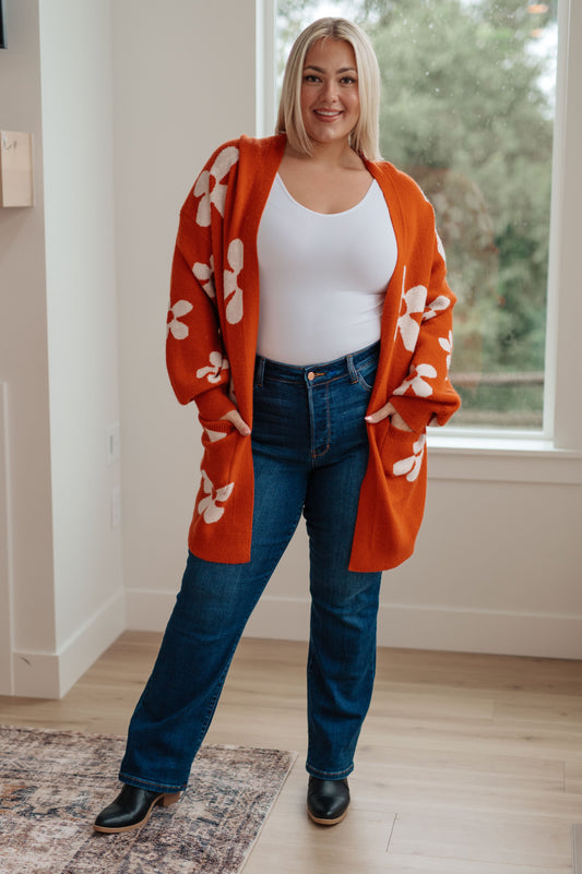 Plus size model wearing Edna Floral Cardigan in burnt orange with open front and roomy fit.