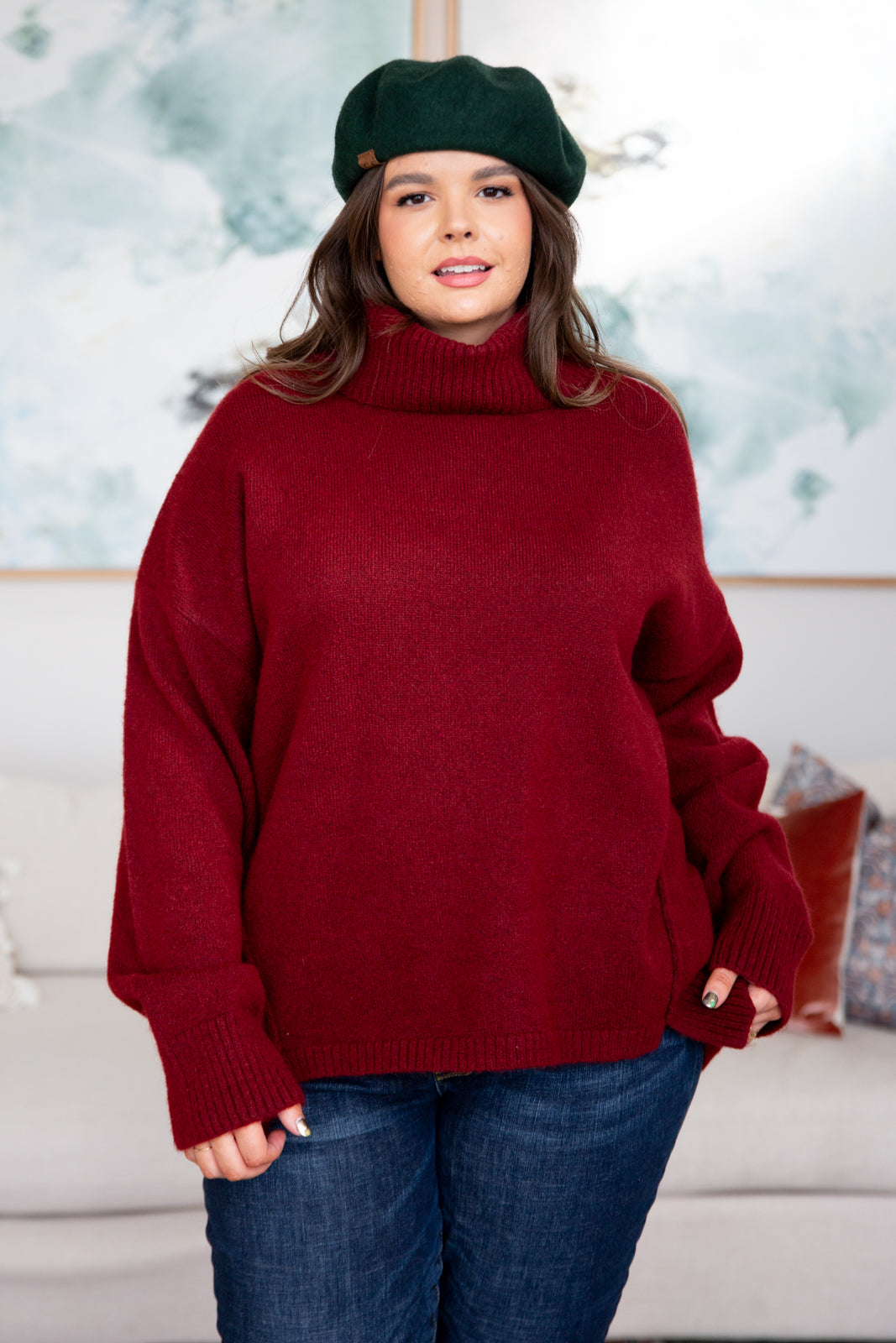 Dark red turtleneck sweater with drop shoulders, ribbed cuffs, and a split, stepped hem.