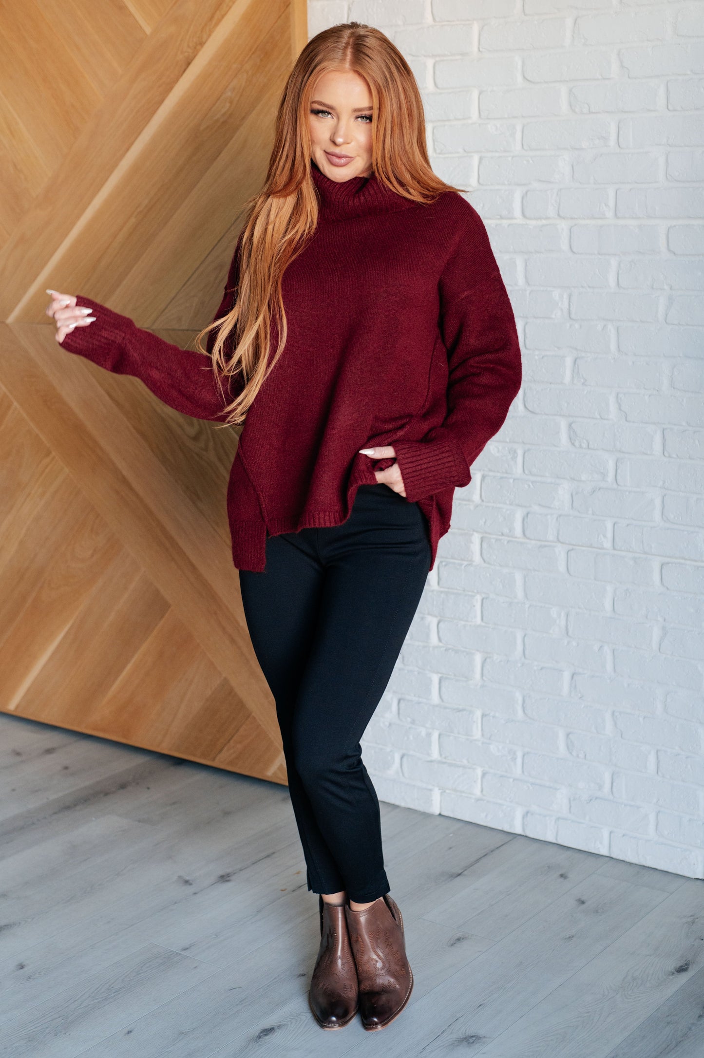 Dark red turtleneck sweater with drop shoulders, ribbed cuffs, and a split, stepped hem.