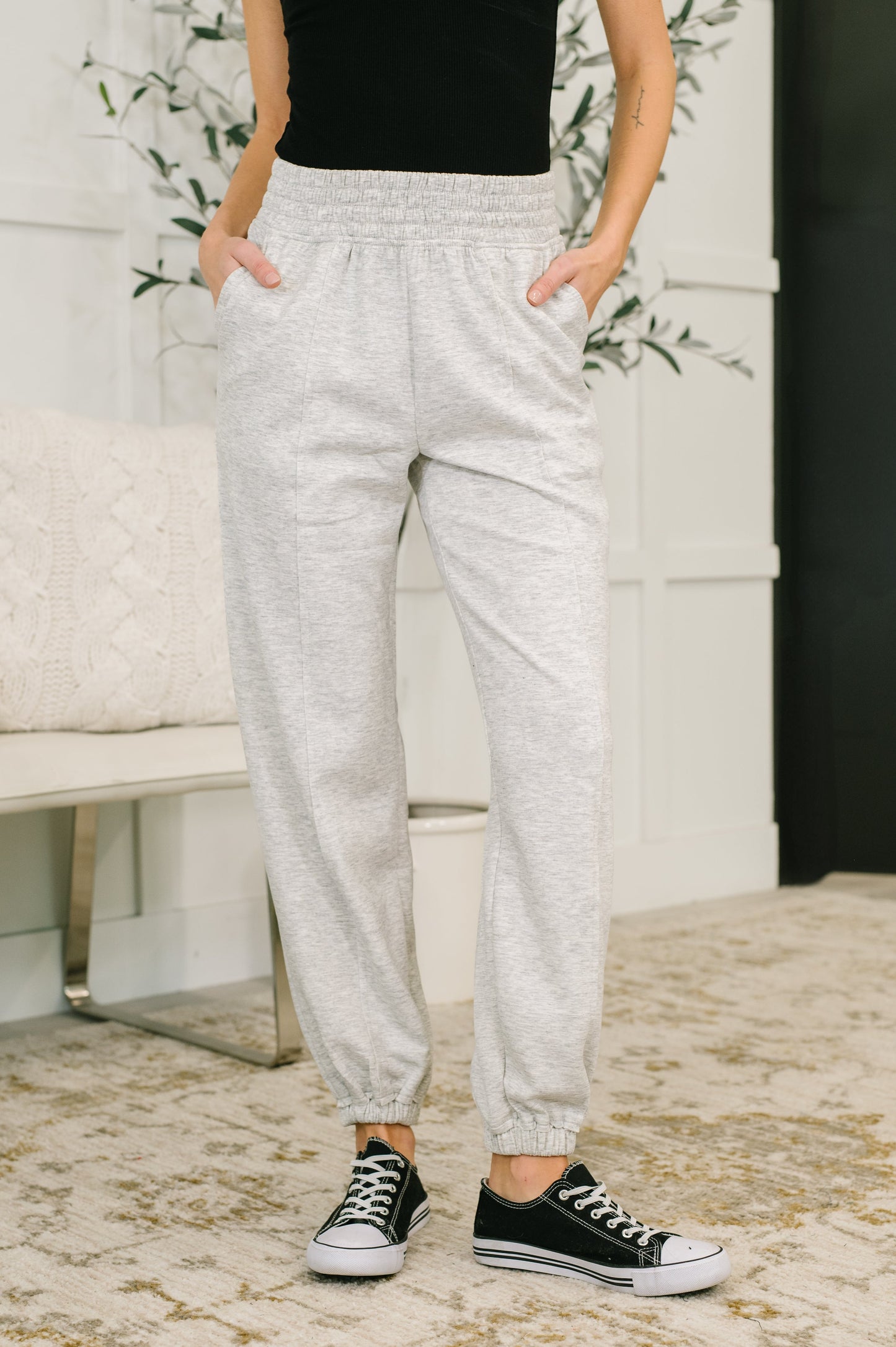 Model wearing Evani Jogger Bottoms in heather gray scuba fabric with elastic waist.