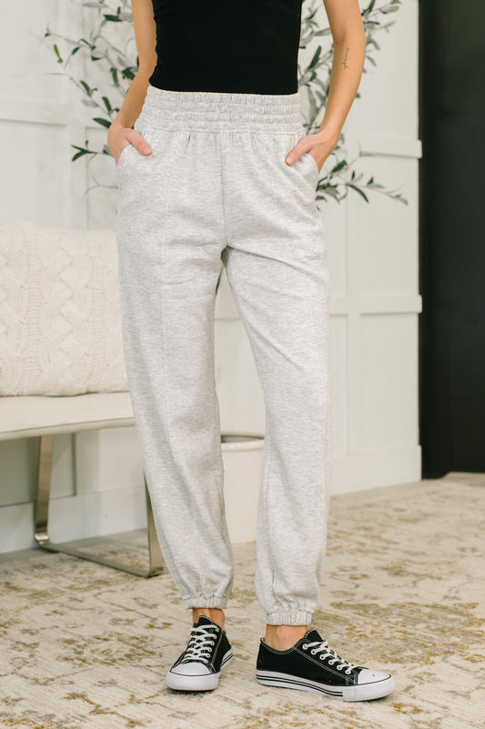 Model wearing Evani Jogger Bottoms in heather gray scuba fabric with elastic waist.